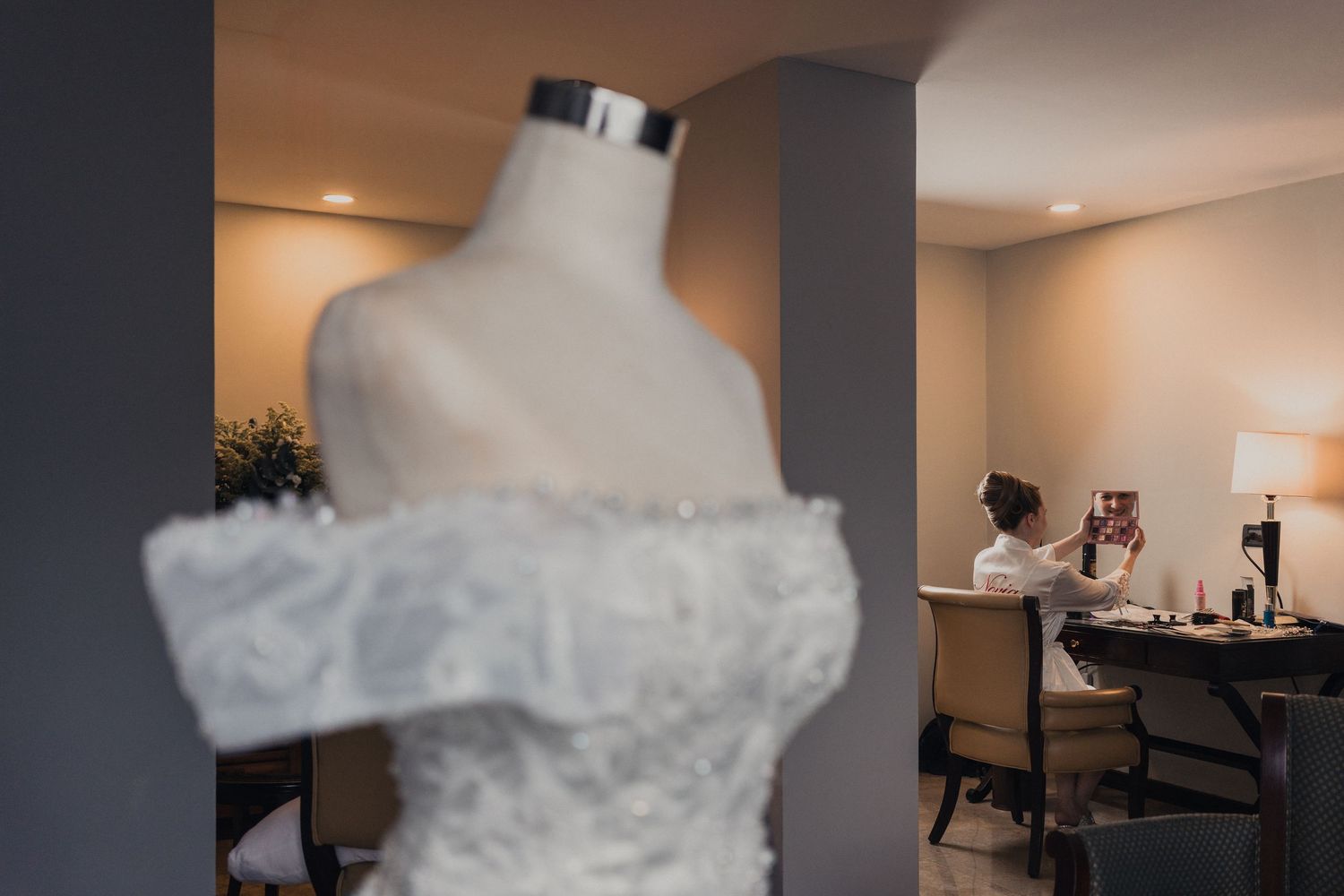 A collection of wedding dress detail shots showing intricate lace patterns and flowing fabric in a bridal suite.