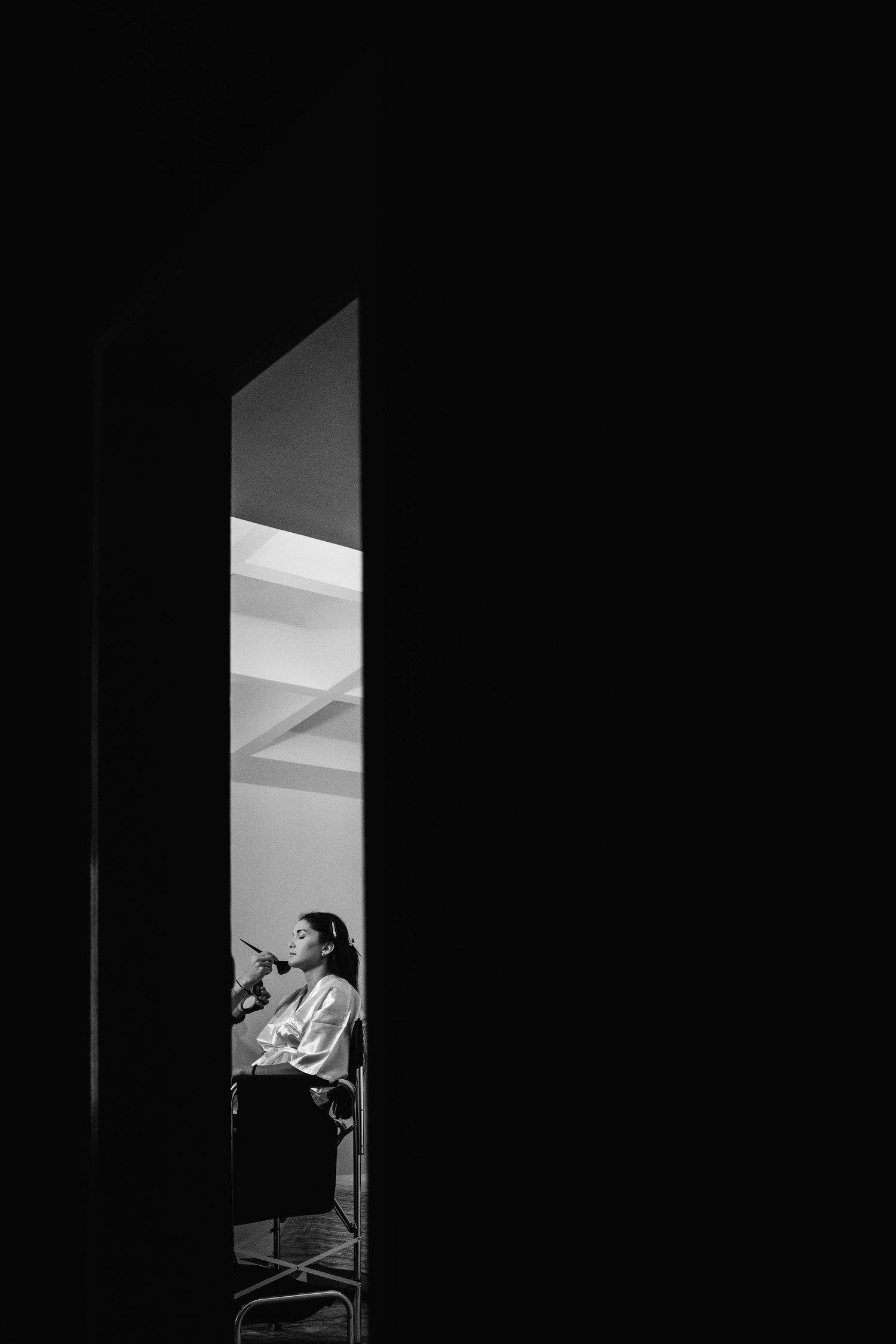 Minimalist black and white photograph showing light through a doorway.