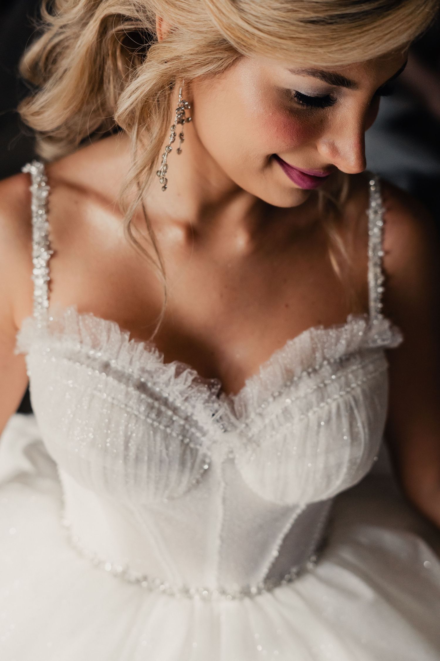 Close-up details of a white beaded wedding dress bodice with delicate lace and sweetheart neckline.