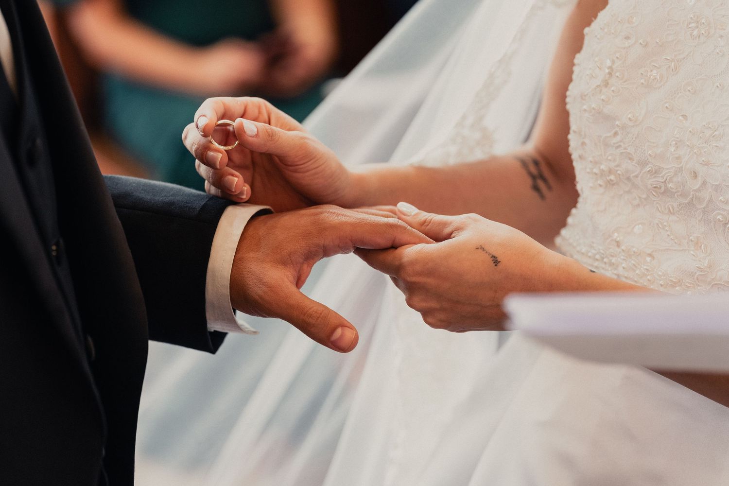 Close-up shots of hands exchanging wedding rings during a ceremony.