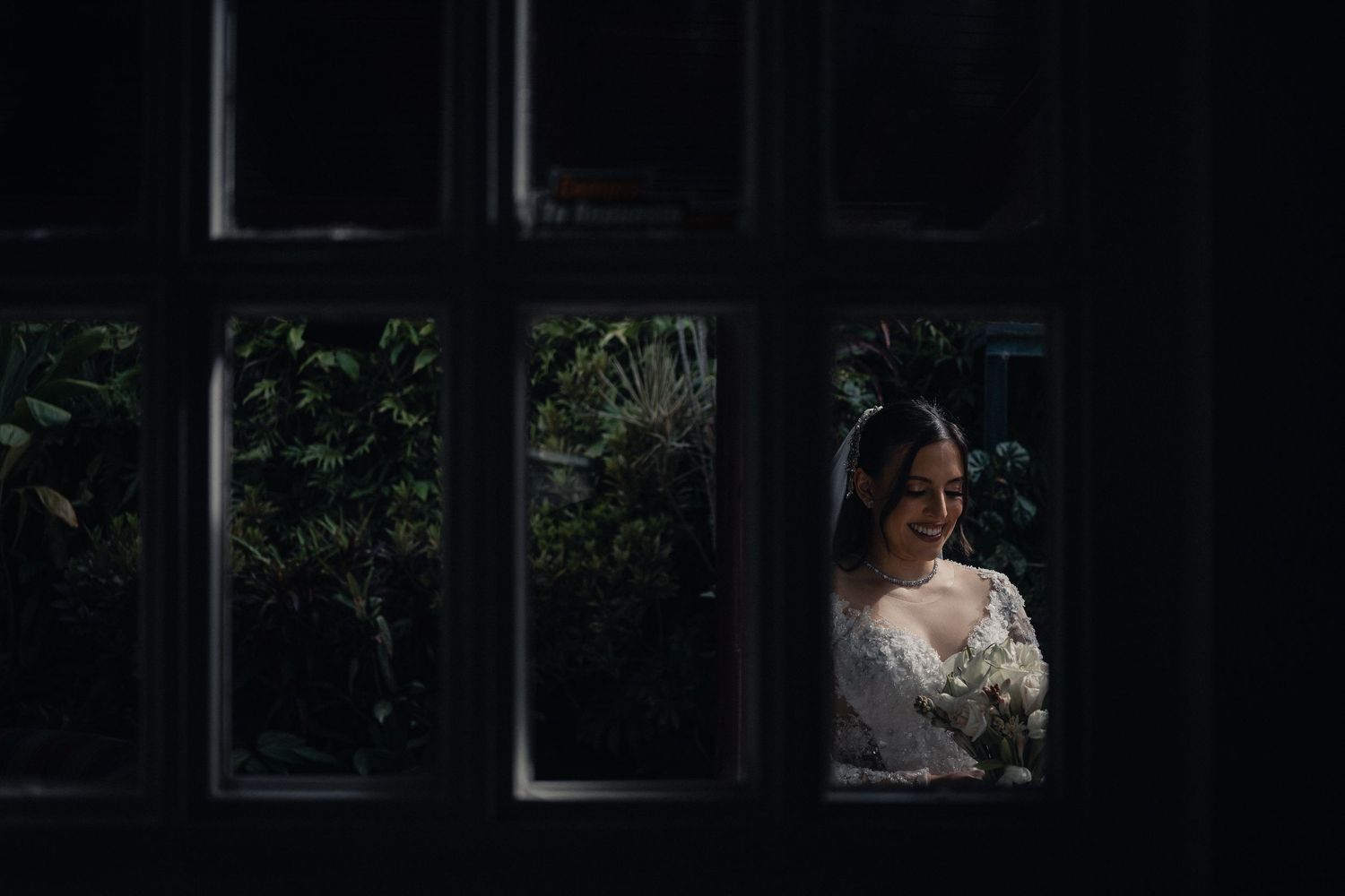 A couple in formal wedding attire poses for romantic photos in a natural outdoor setting.