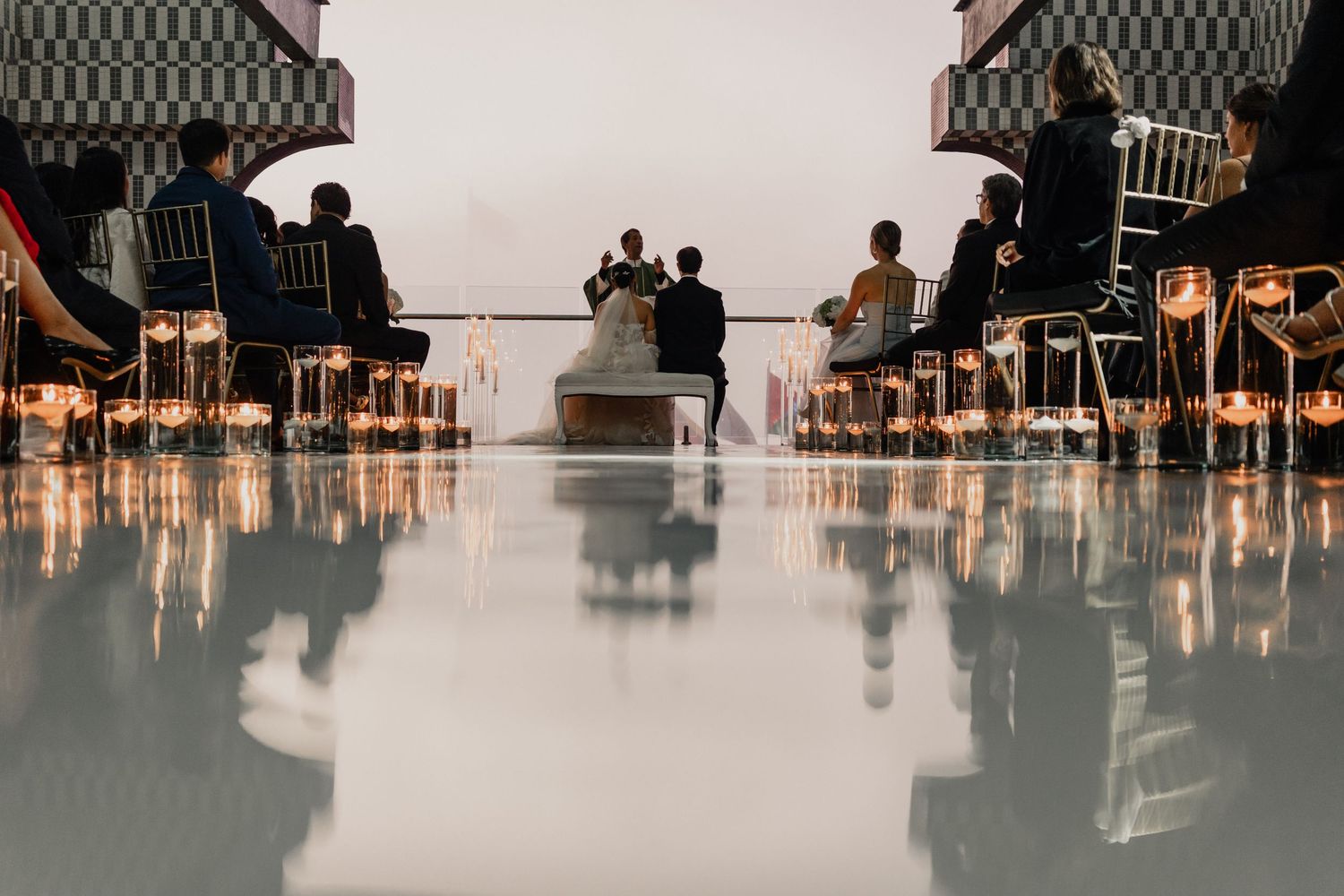 Wedding guests dance and celebrate on a dimly lit dance floor during an evening reception.