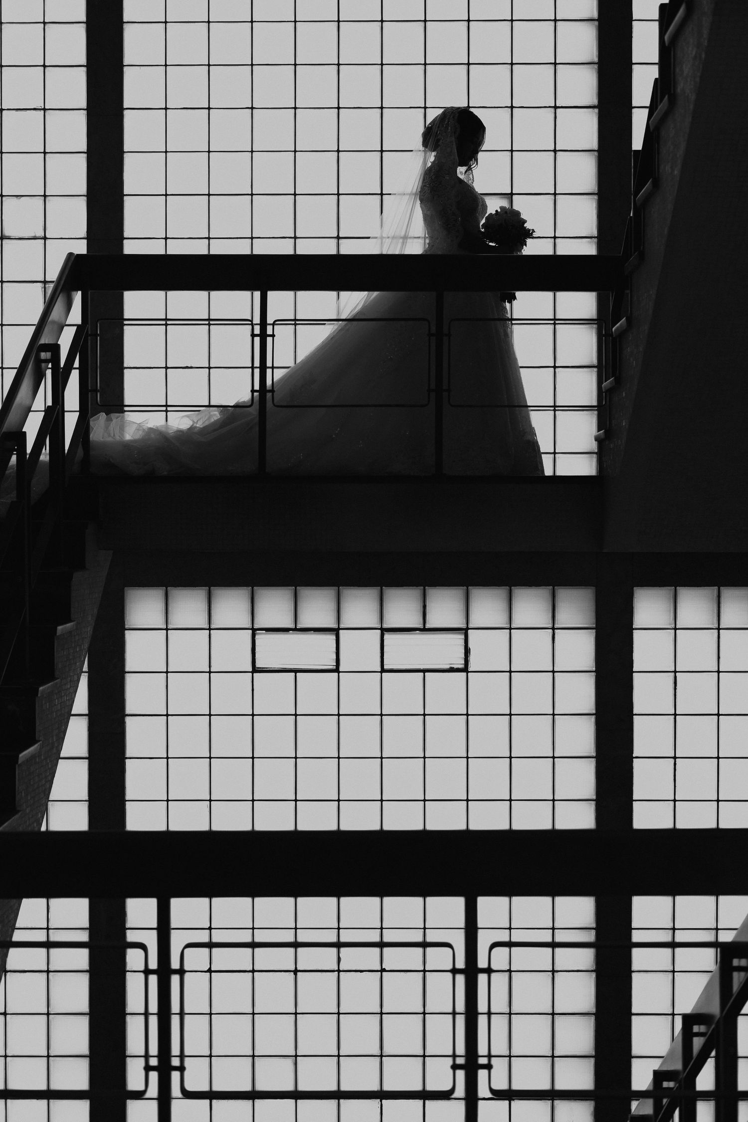 Silhouettes of people sitting on bleachers or stadium seating against a white grid background.