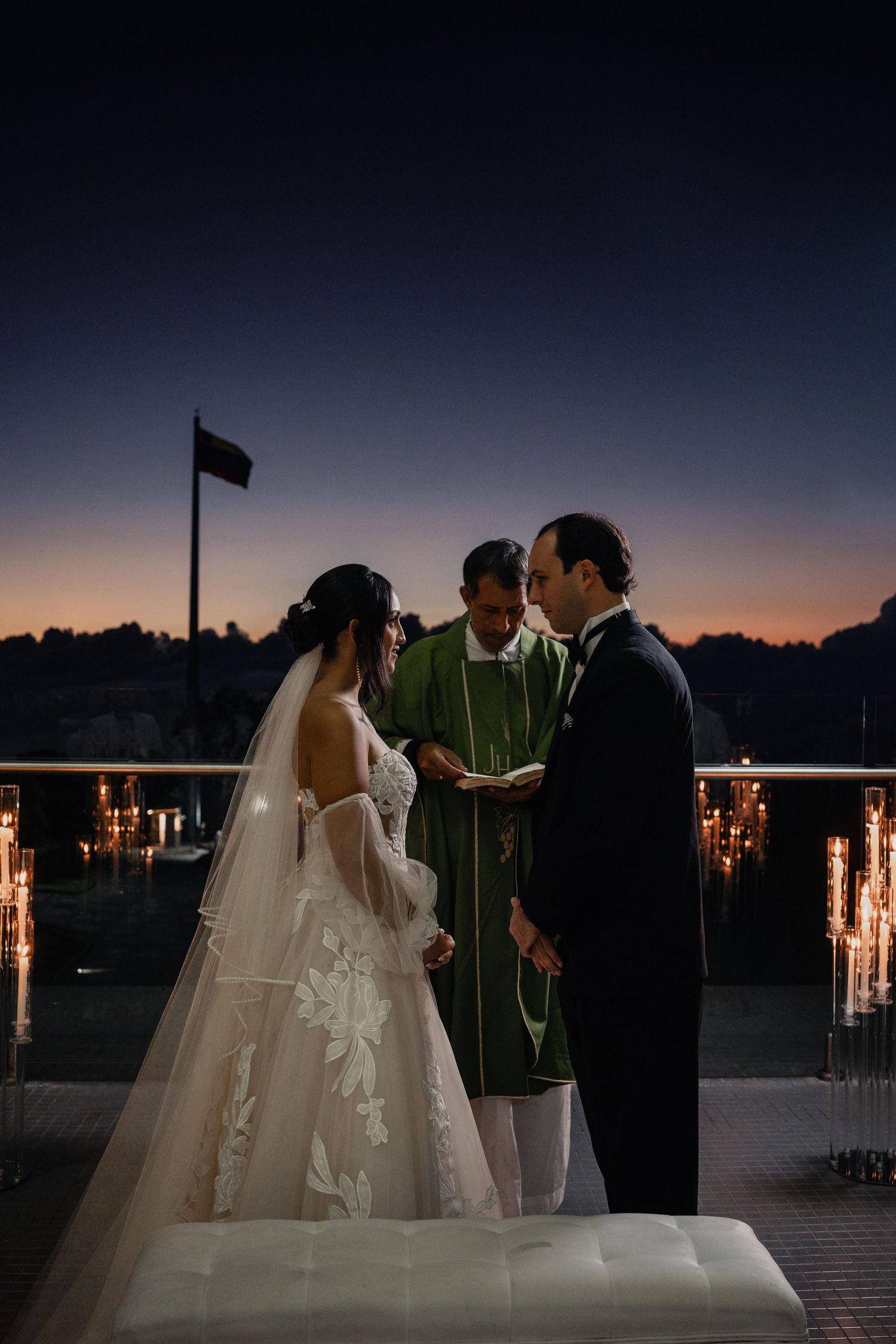 Romantic sunset wedding ceremony on a pier with glowing lanterns creating a magical atmosphere.