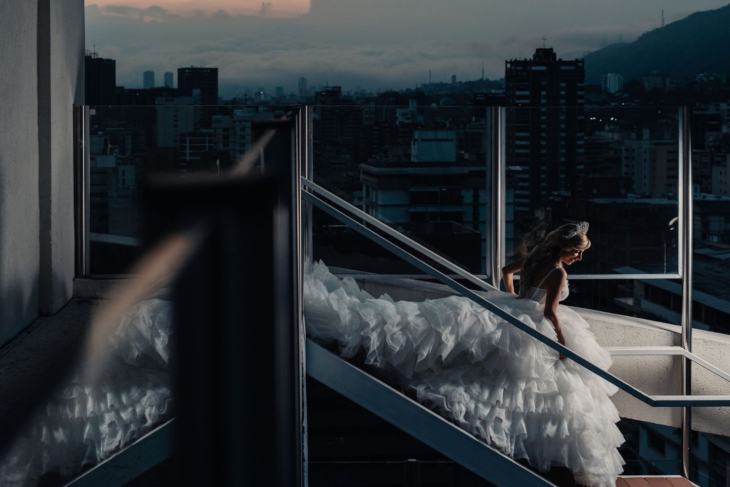 A modern glass-walled office building interior with panoramic city views and sleek architectural details at sunset.