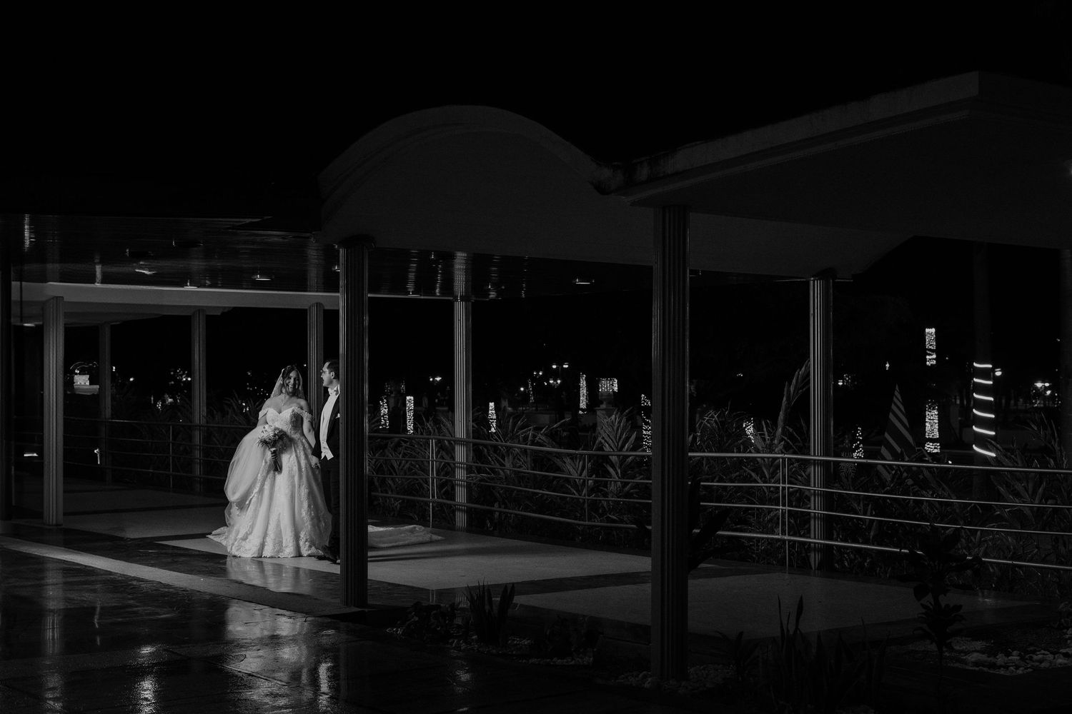 Elegant wedding reception venue with dramatic lighting and table settings in a spacious ballroom.