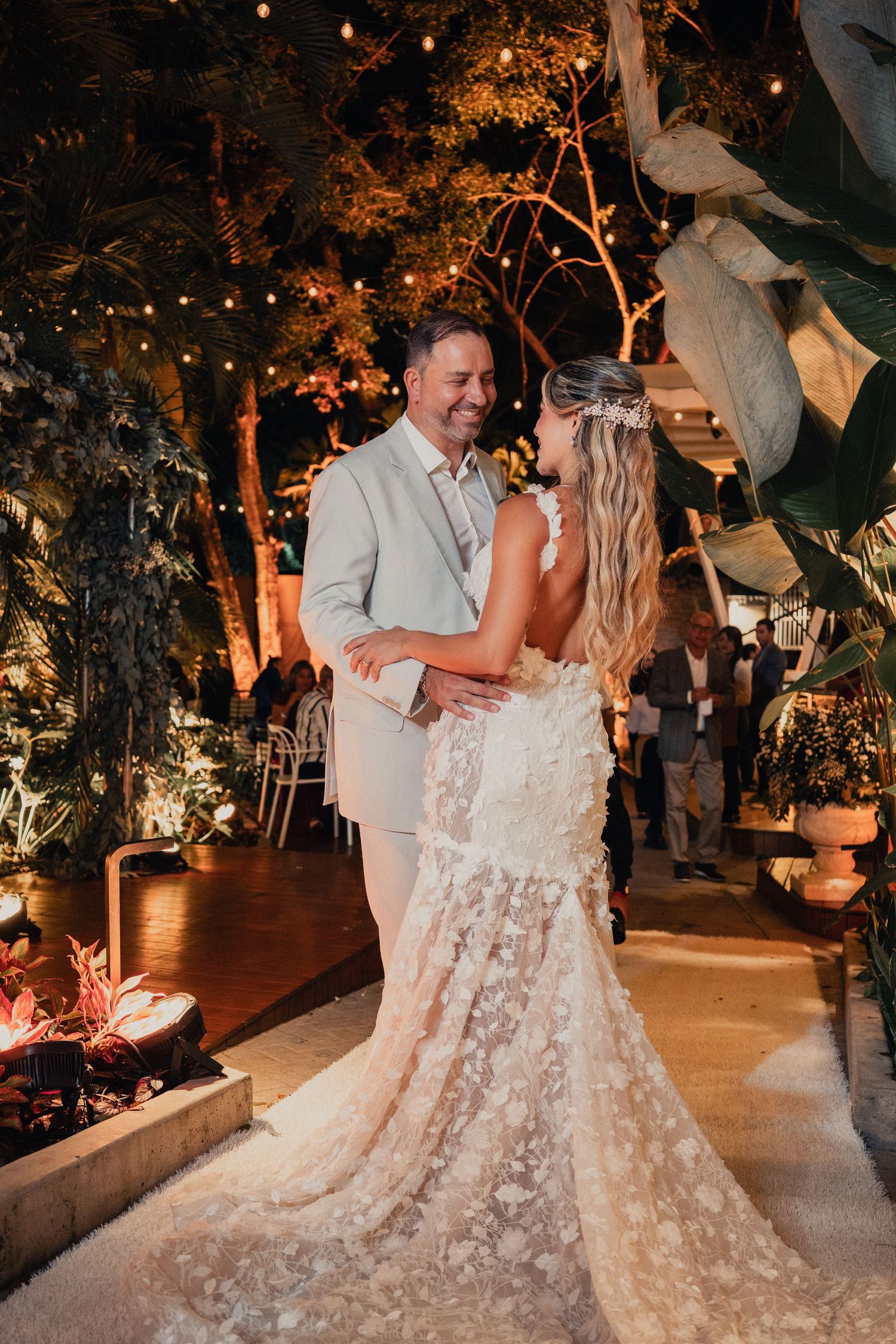 Romantic evening wedding dance scene with string lights and trees creating a magical outdoor ambiance.