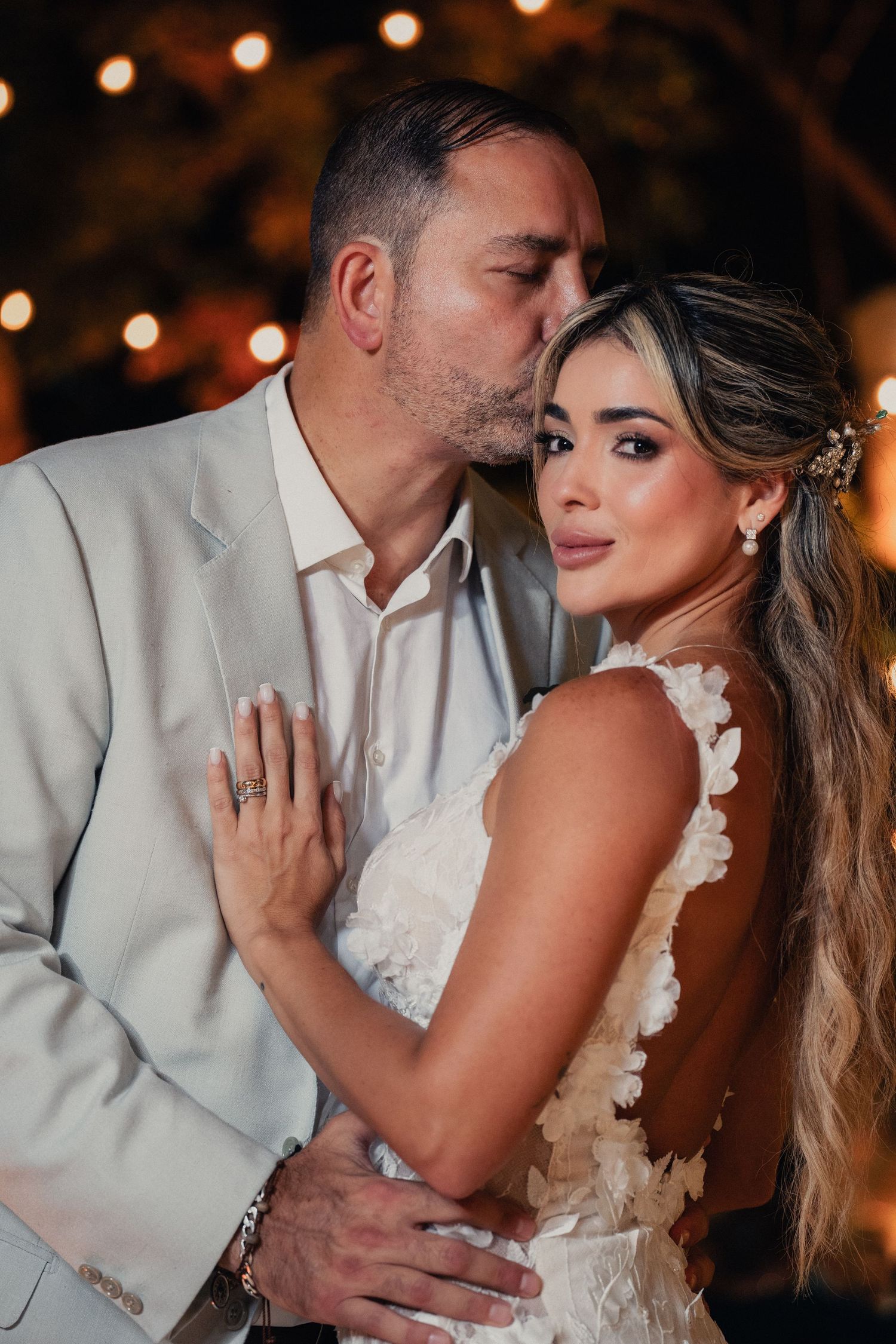 Intimate evening portrait with warm string lights creating a romantic ambiance.