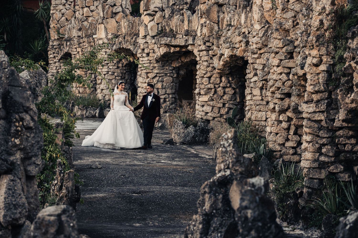 Stone archways and rustic walls create a dramatic backdrop for wedding photography.