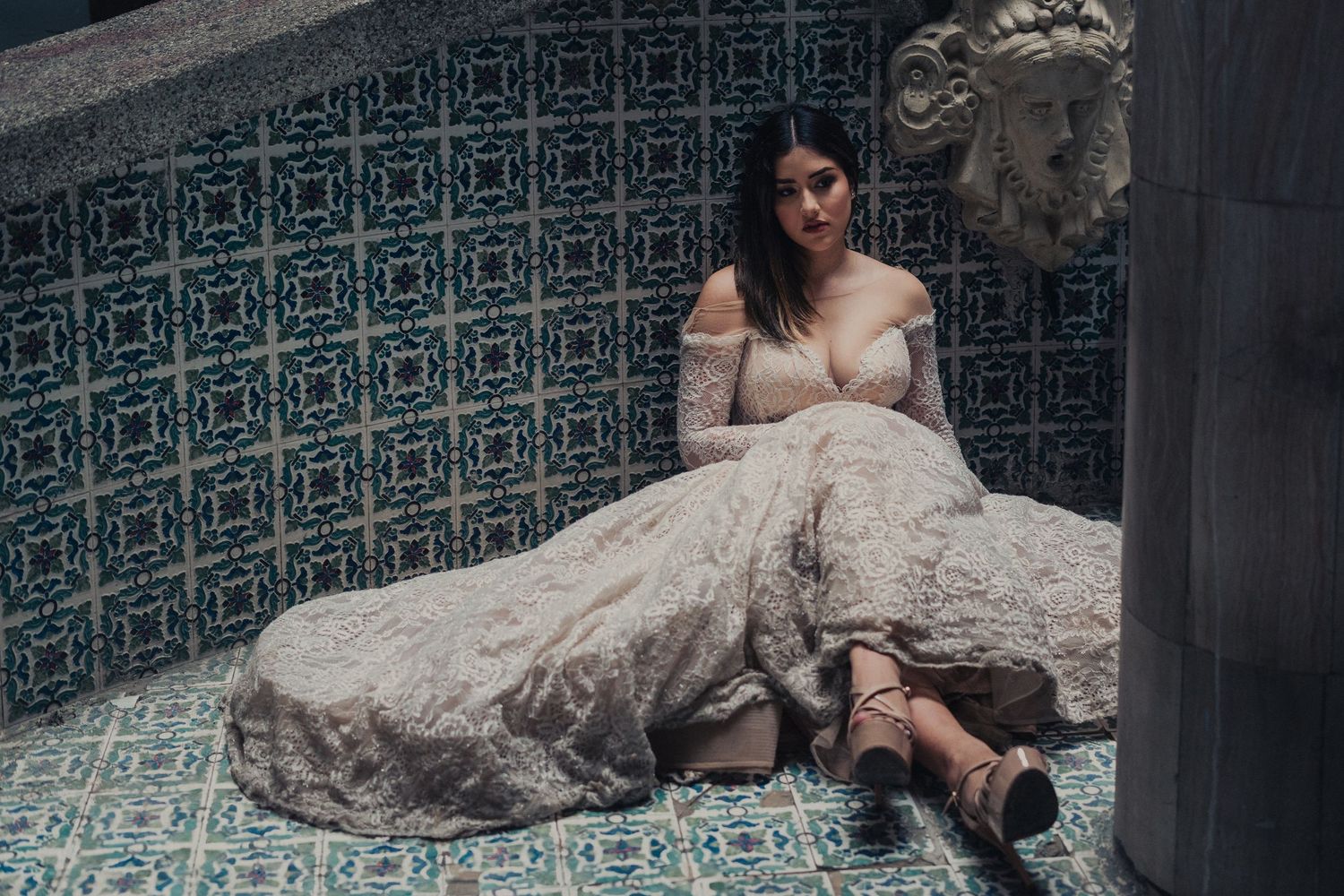 Elegant bridal portrait session featuring a flowing gown against ornate blue and white tiled wall background.