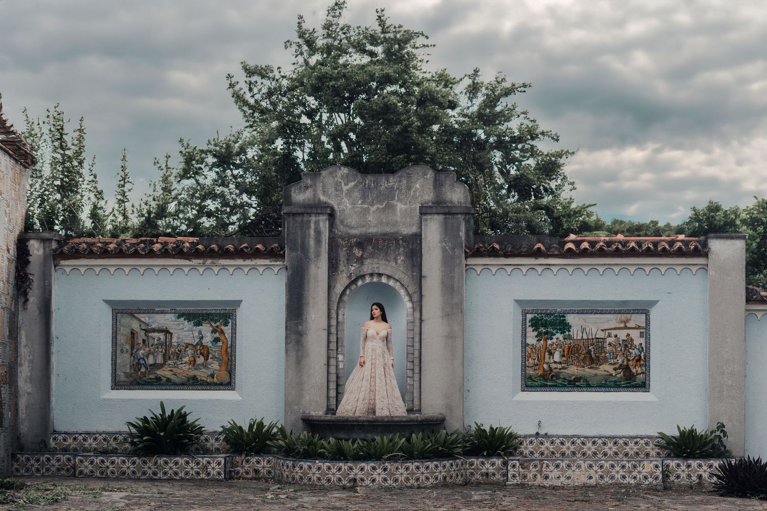 Wedding photography location with white garden walls and decorative framed artwork in an outdoor setting.
