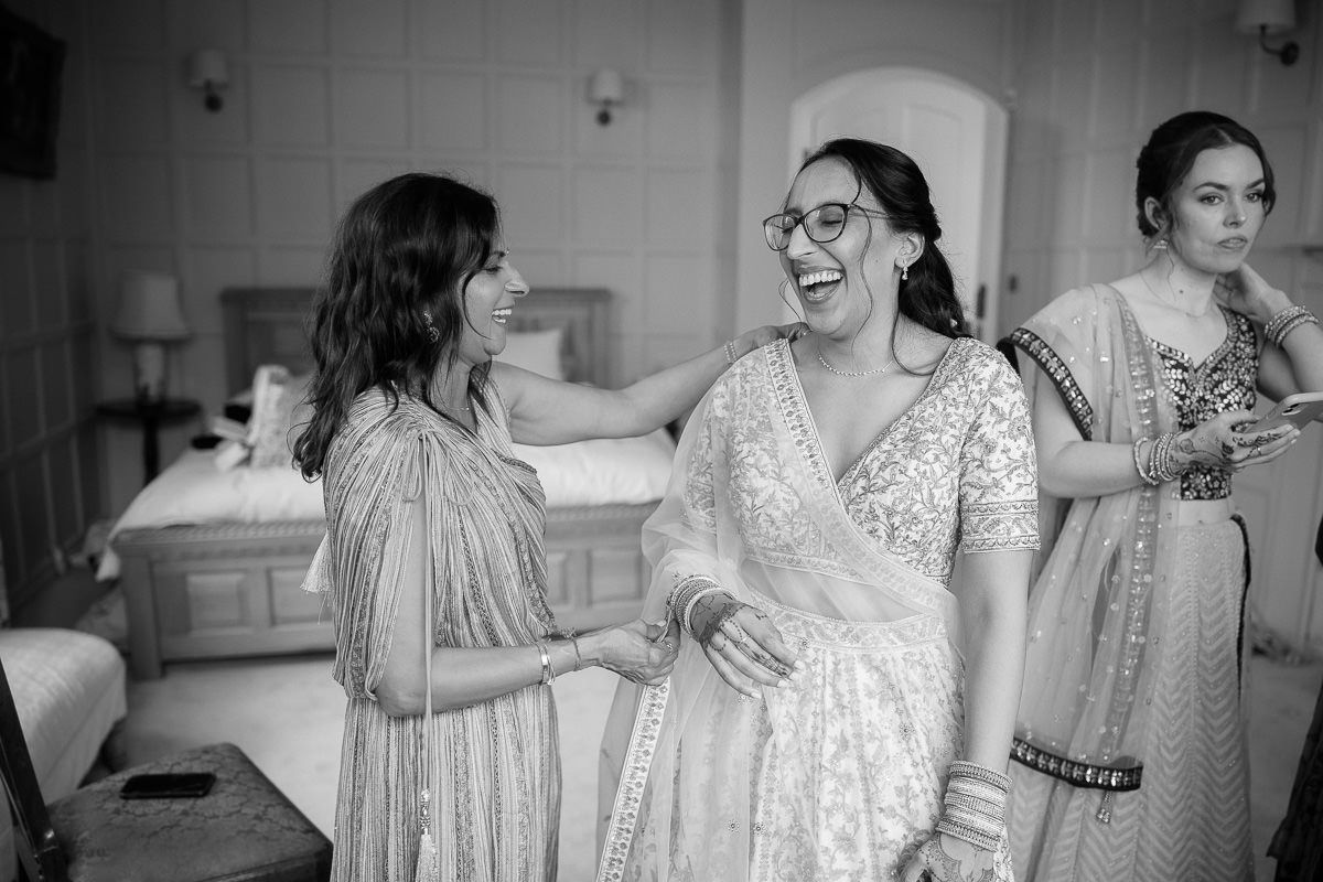 Black and white wedding photos showing joyful moments of preparation and celebration in a bridal suite.