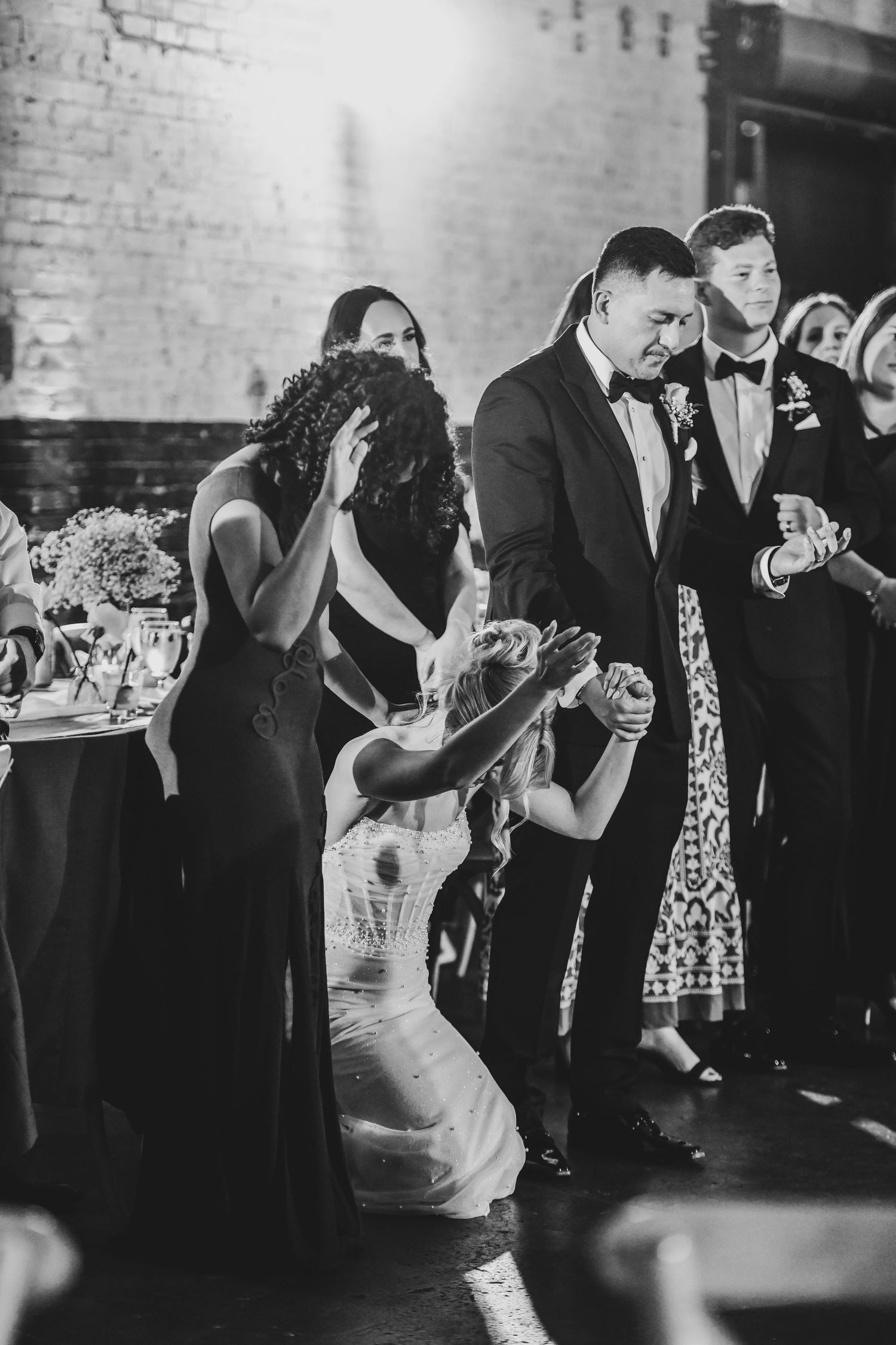 Bride and groom praying together during reception moment