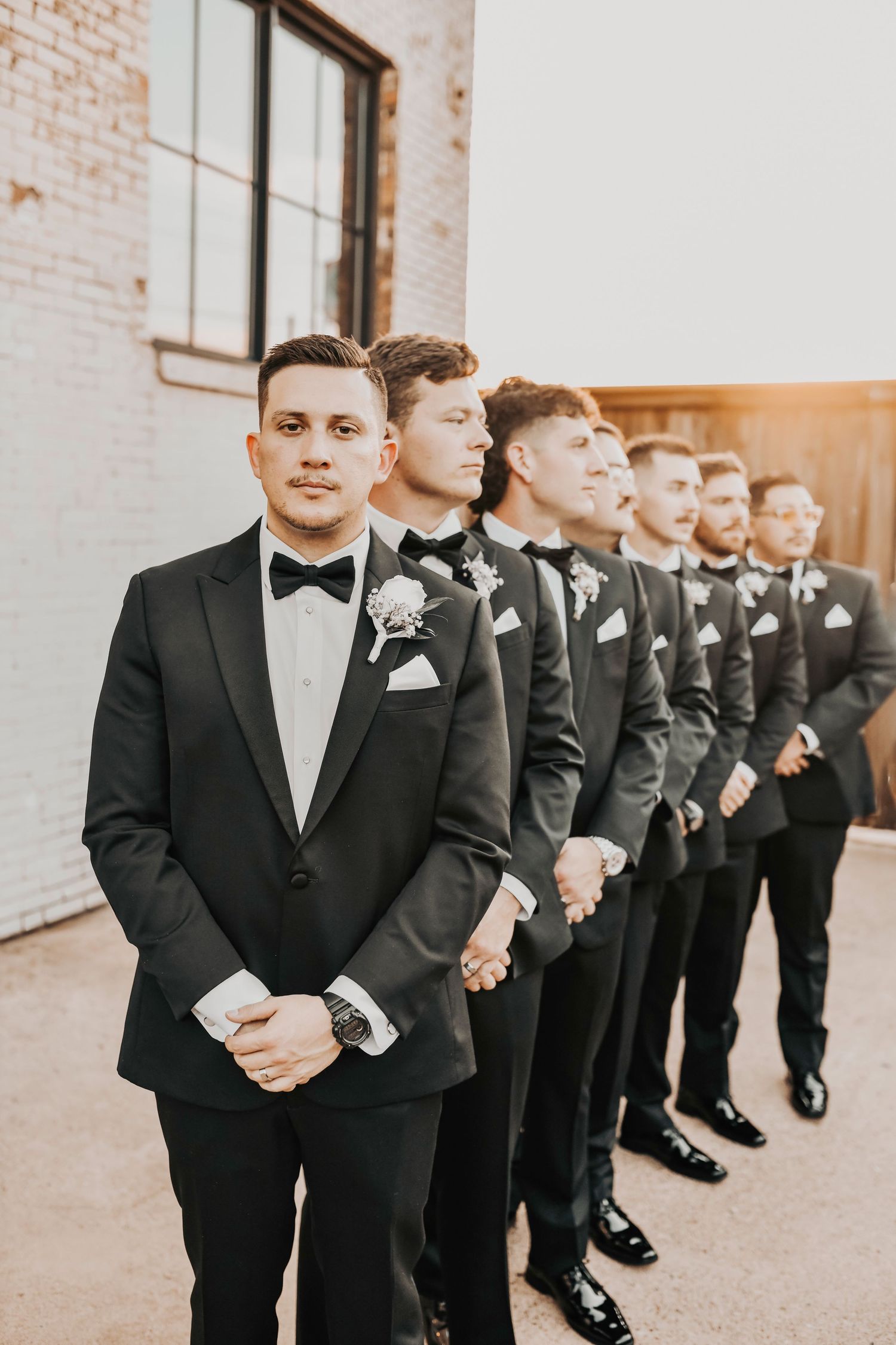 Editorial portrait of groom with his guys in formal tuxedos