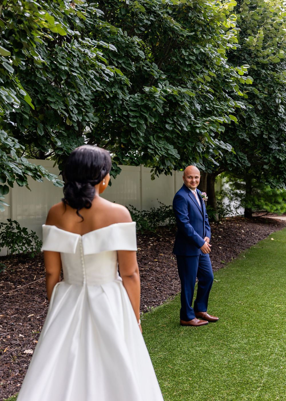 Garden wedding ceremony setup with lush greenery and manicured lawn.