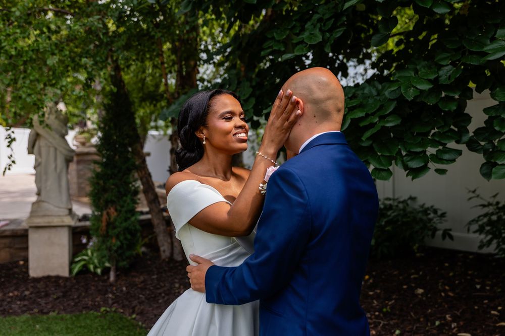 A romantic wedding moment captured in a garden setting with lush greenery and elegant attire.