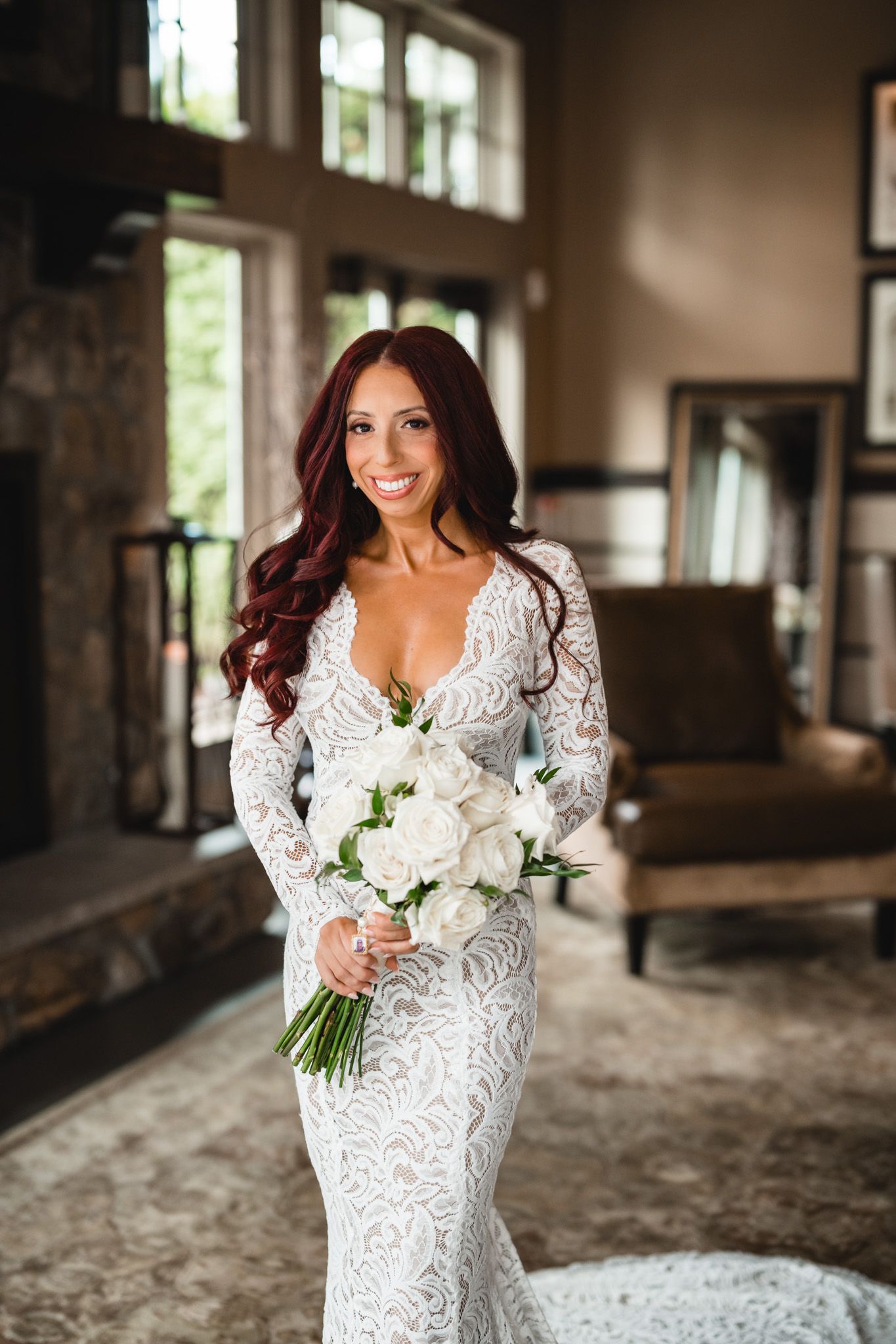 Beautiful wedding dress details with lace and a white bouquet in an elegant indoor setting.