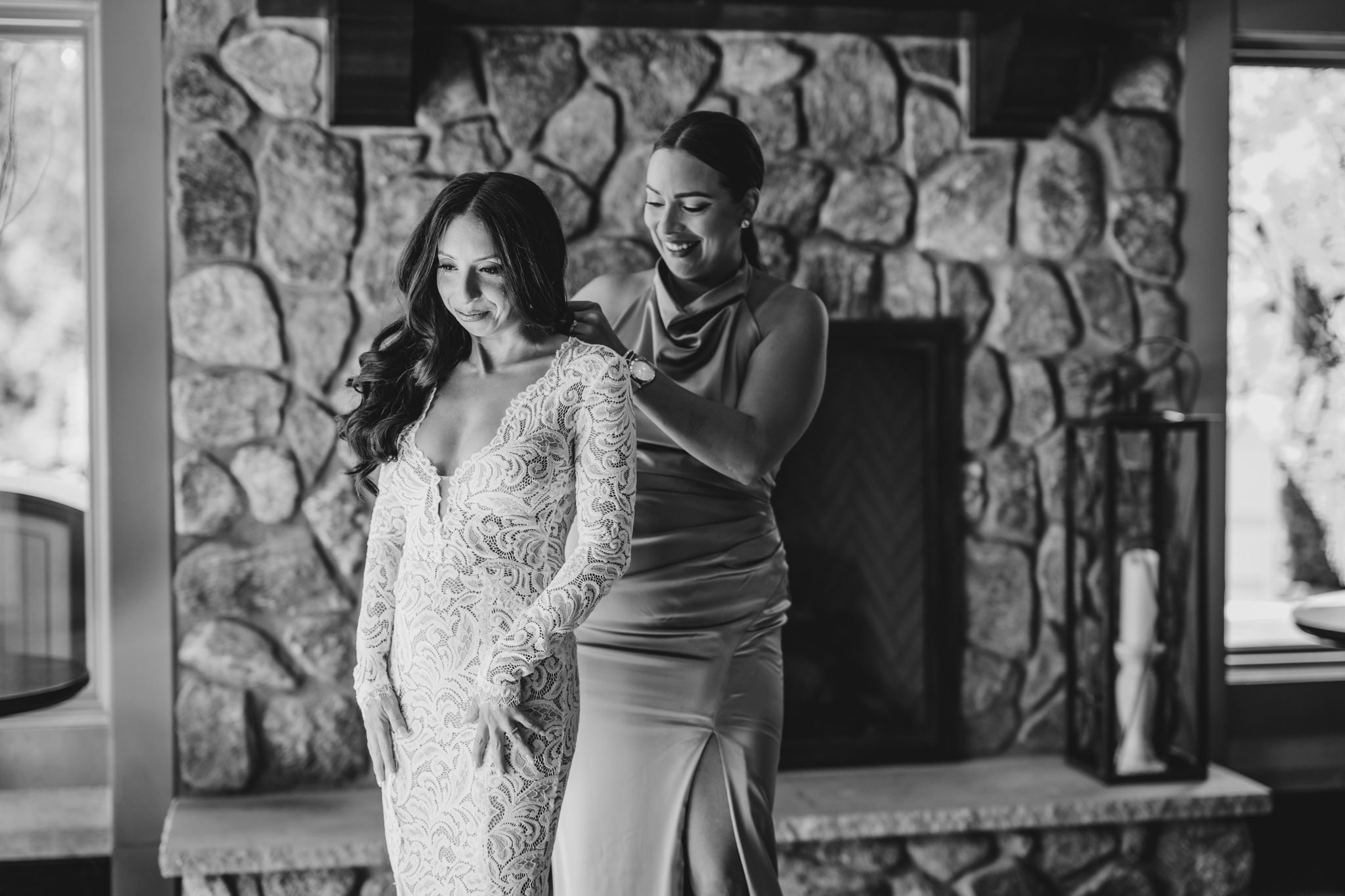 A romantic first dance moment captured in black and white at a wedding reception with stone walls.