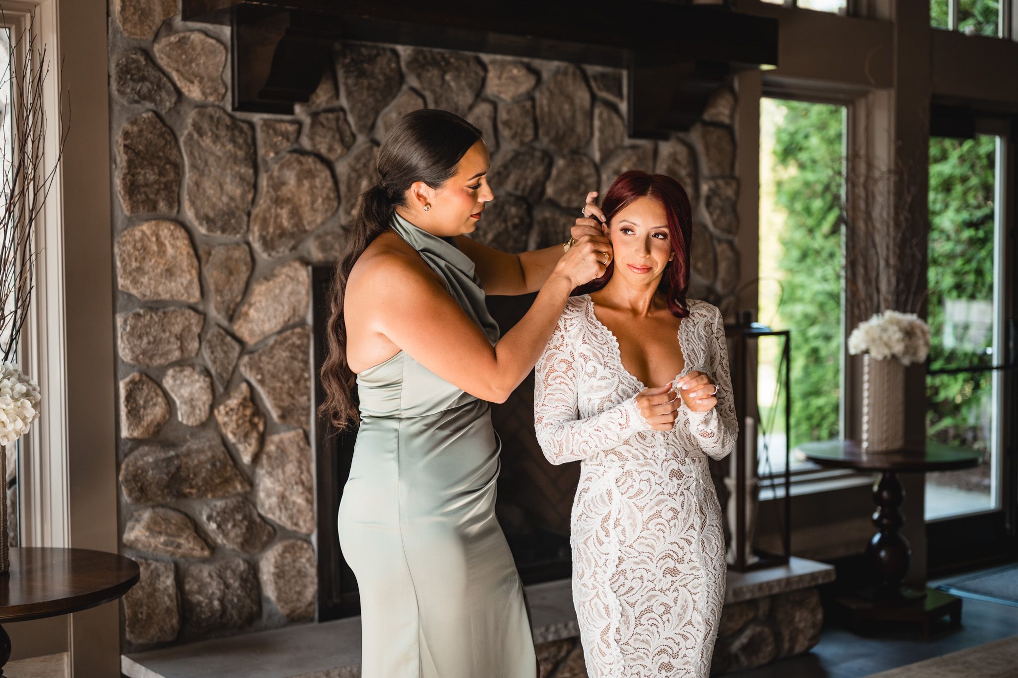 A couple shares an intimate dance in front of a rustic stone wall backdrop.