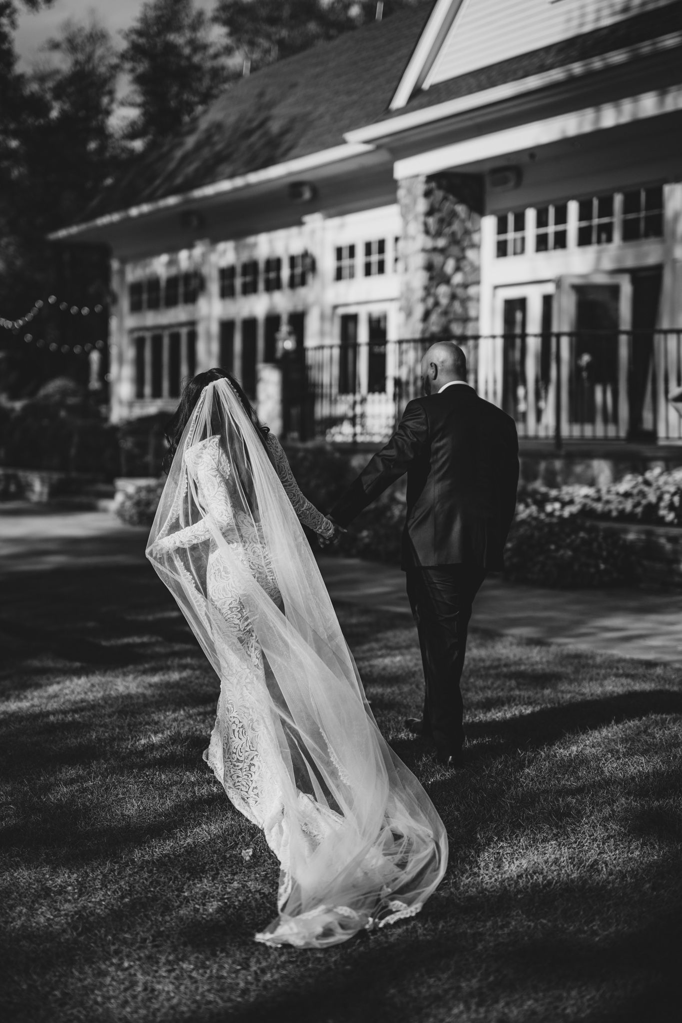 Black and white wedding photos captured in front of a classic white building.