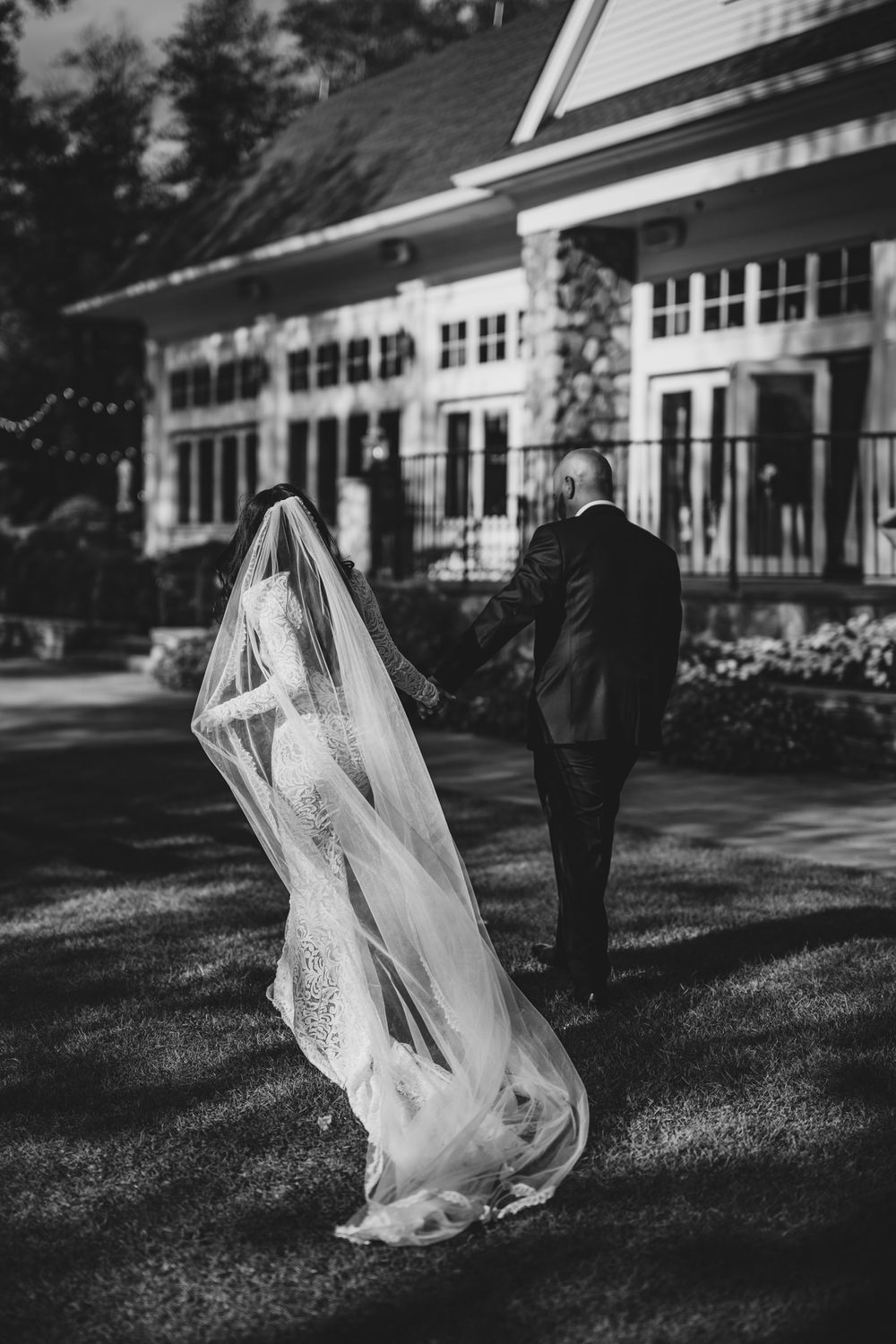 Black and white wedding photos captured in front of a classic white building.