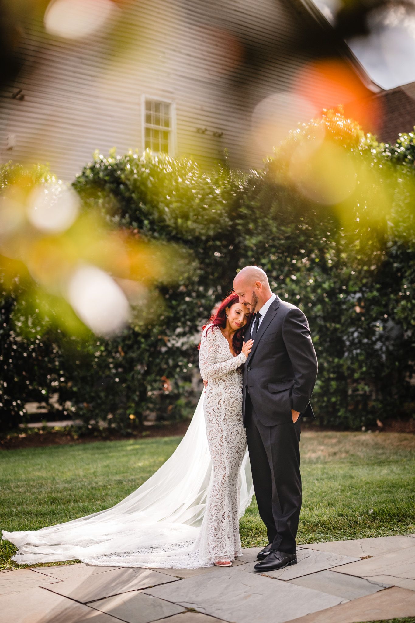 Romantic wedding portrait with dreamy bokeh lighting effects in garden setting.
