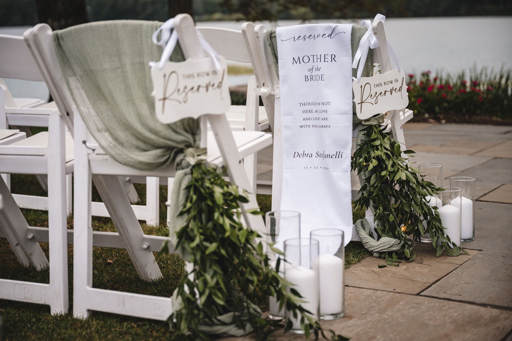 Reserved seating signs with floral accents line the wedding ceremony aisle.