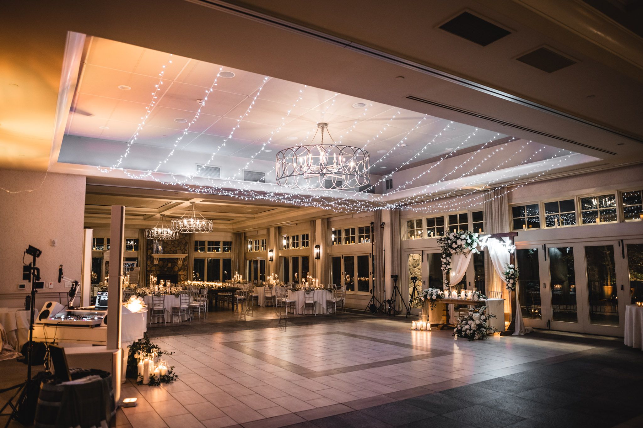 Elegant ballroom reception venue with chandelier and mood lighting.