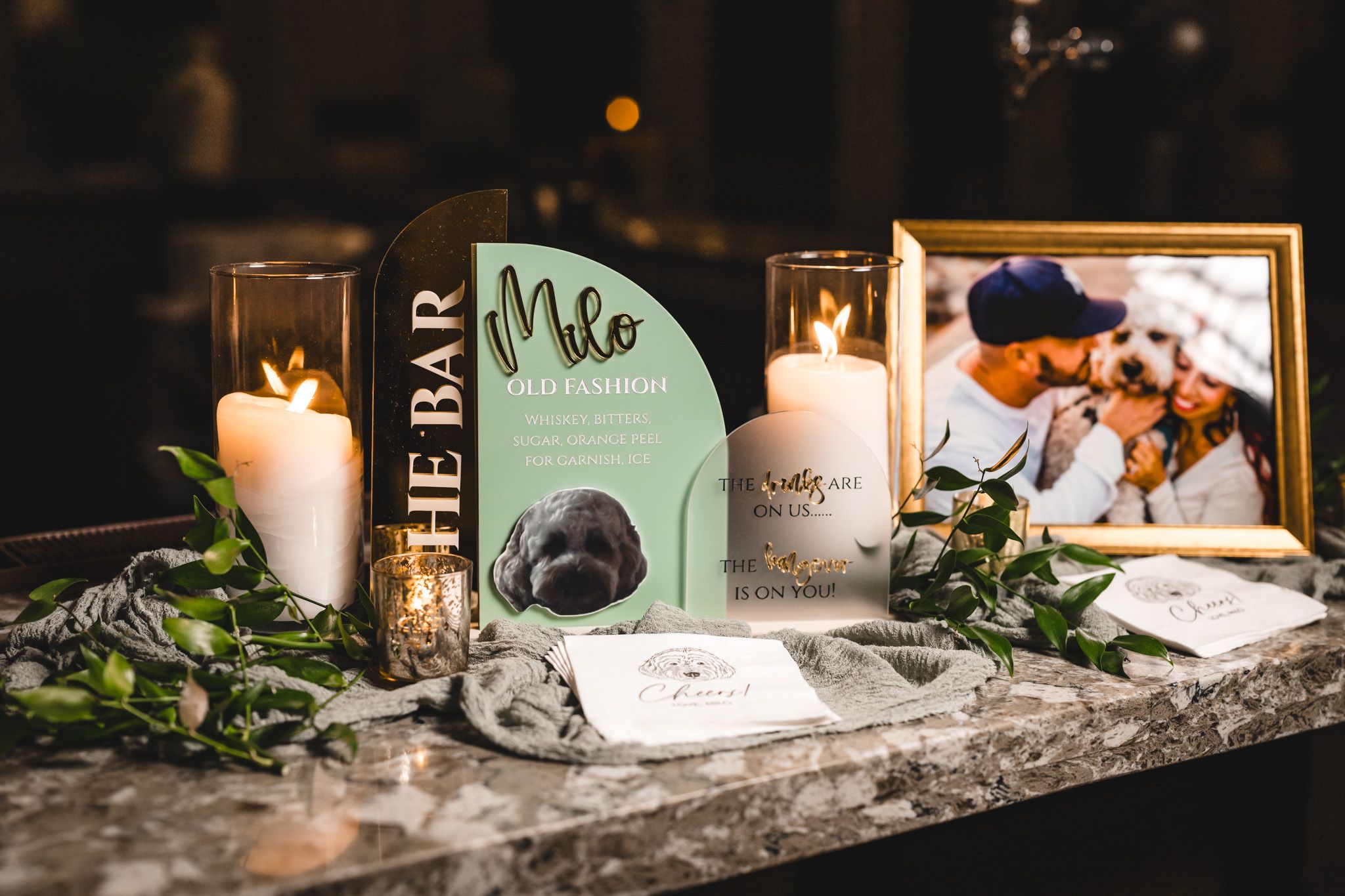 Wedding memorial table with candles, photos and decorative items on marble surface.