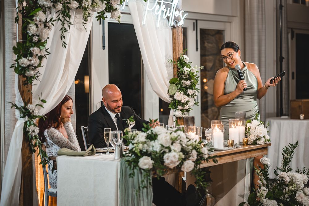 Candlelit wedding reception table decorated with white roses and elegant draping.