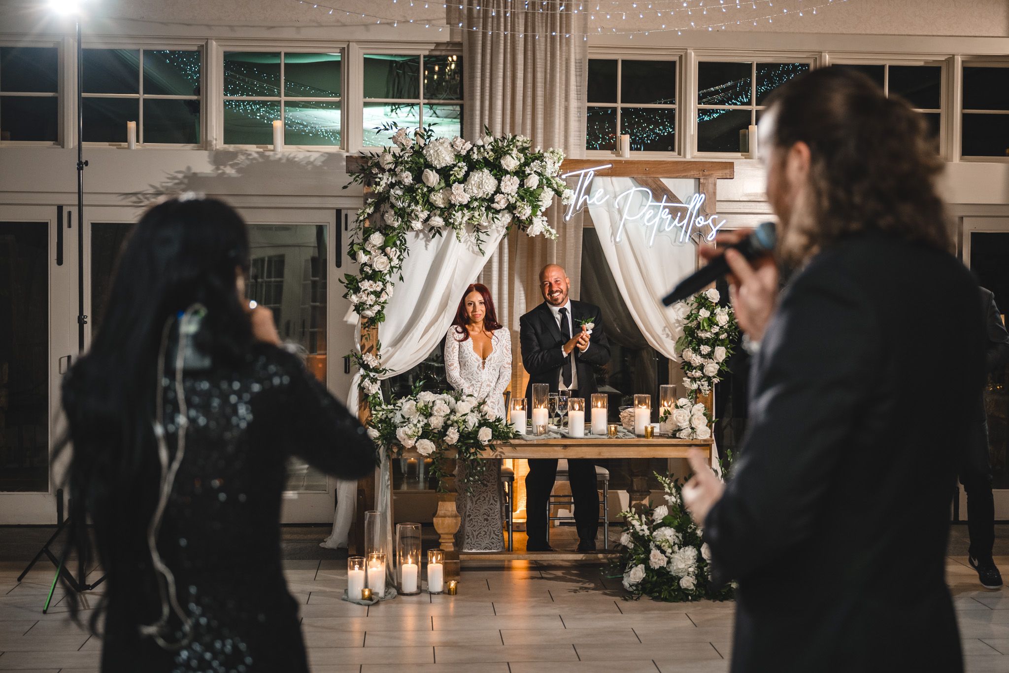 Wedding reception venue decorated with floral arrangements and soft lighting for evening celebration.
