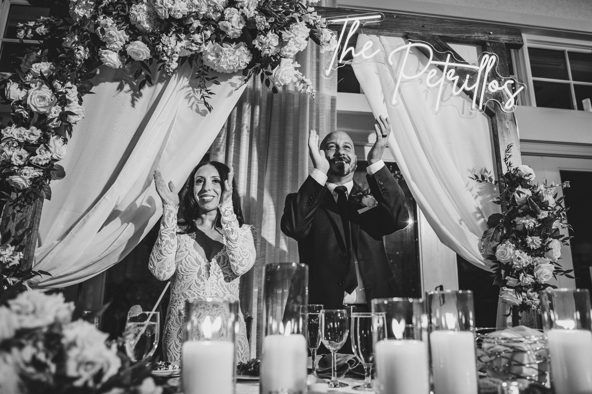 Elegant wedding ceremony setup with white floral arch and candle decorations.