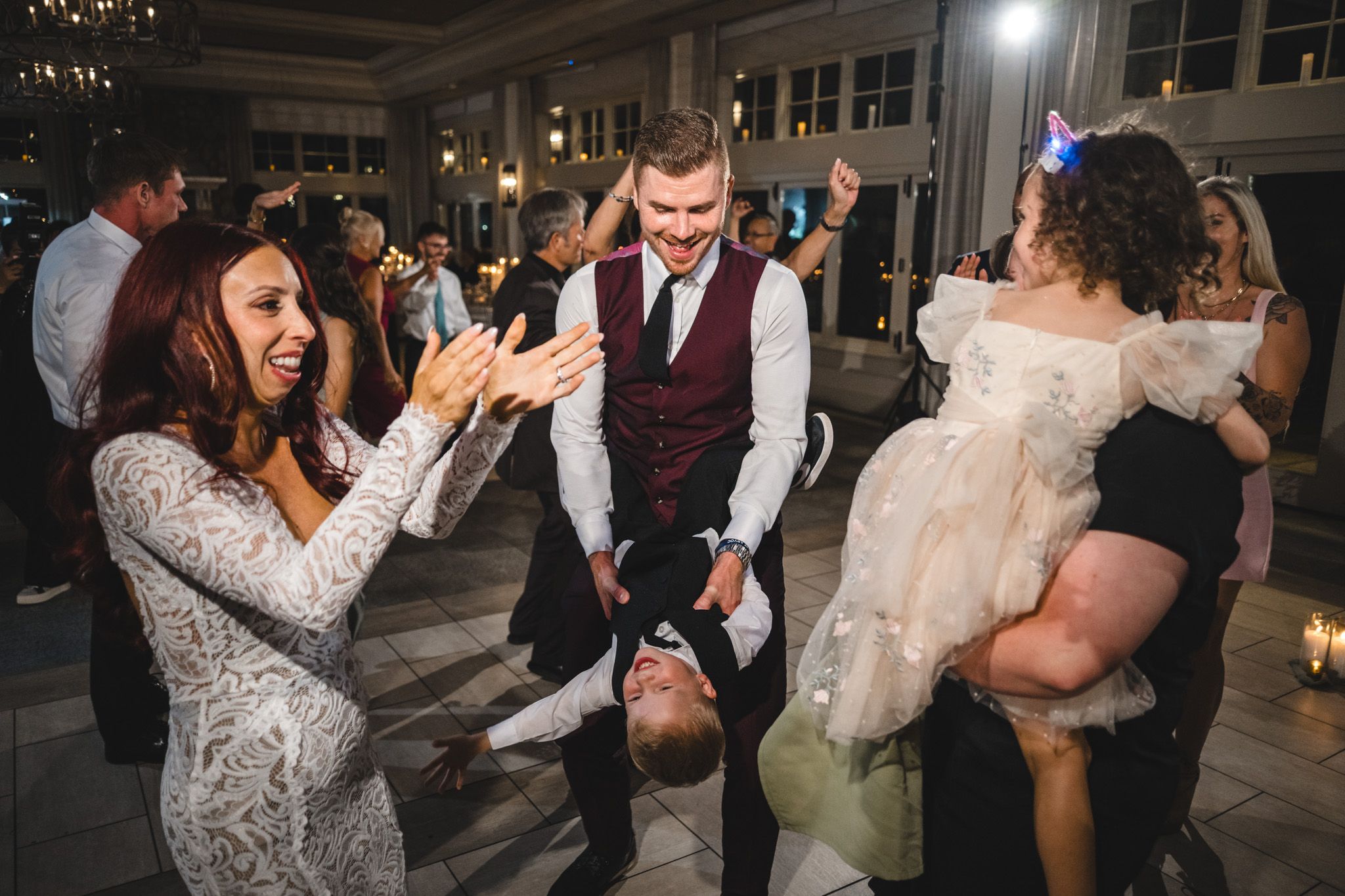 Wedding reception dance floor filled with guests celebrating and dancing.