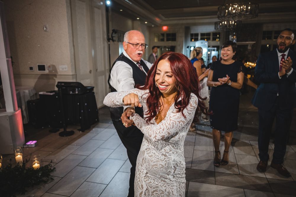 Lively dance party at wedding reception with guests in formal attire.