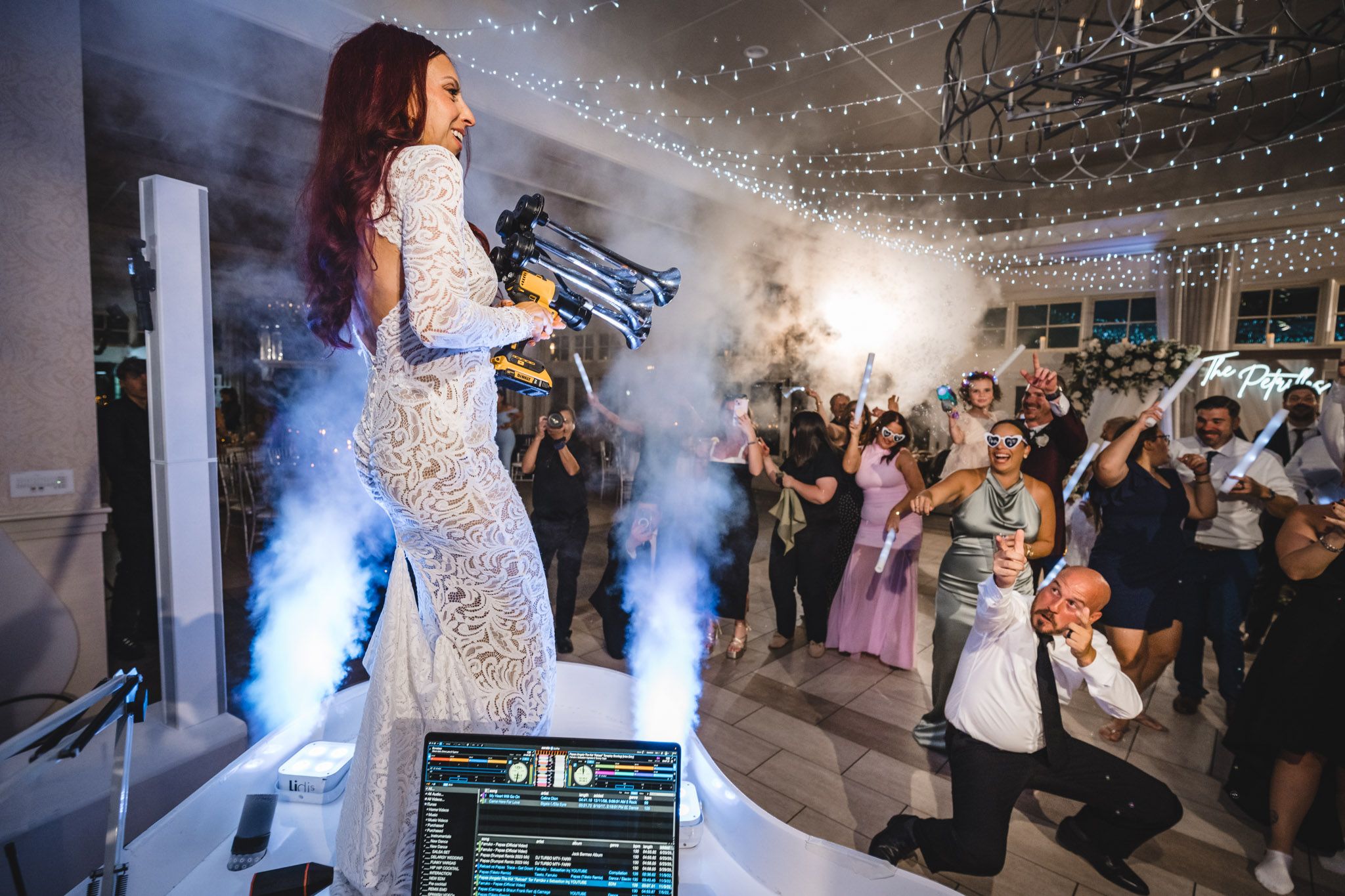 Wedding celebration features dramatic blue smoke effects and twinkling string lights during evening festivities.