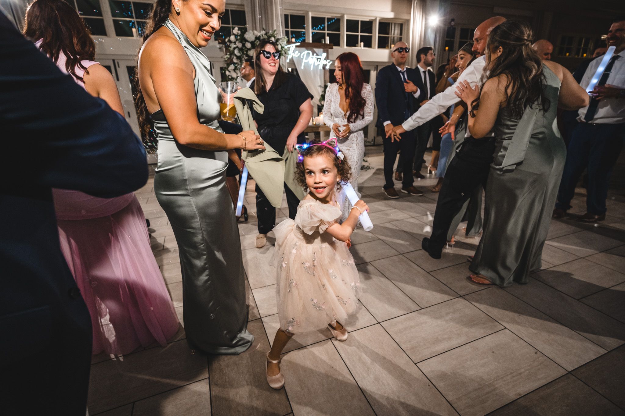 Wedding reception guests dance with glowing LED sabers creating a festive light show atmosphere.
