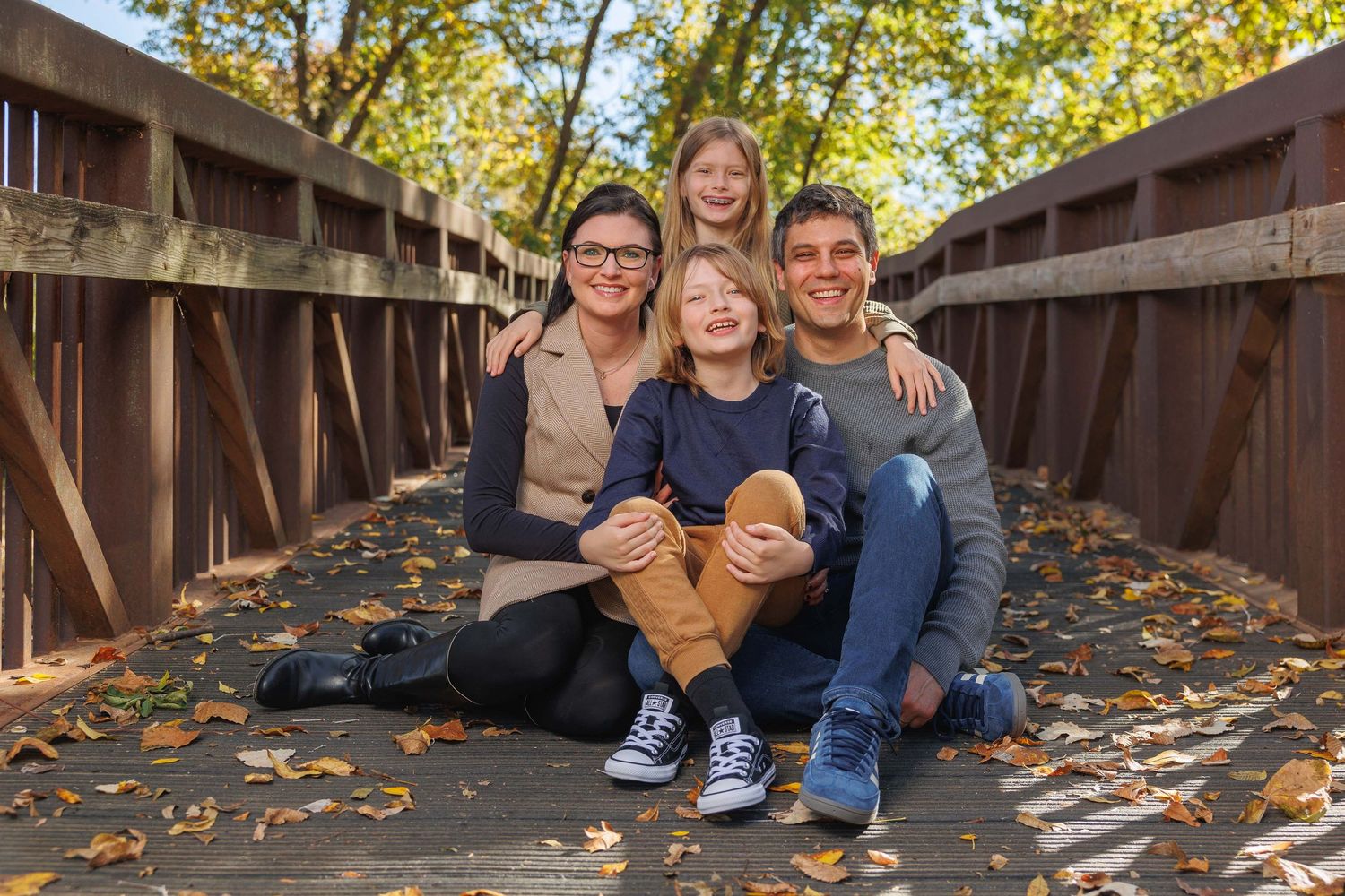 Black and white family portrait series showing candid moments outdoors in a natural setting.