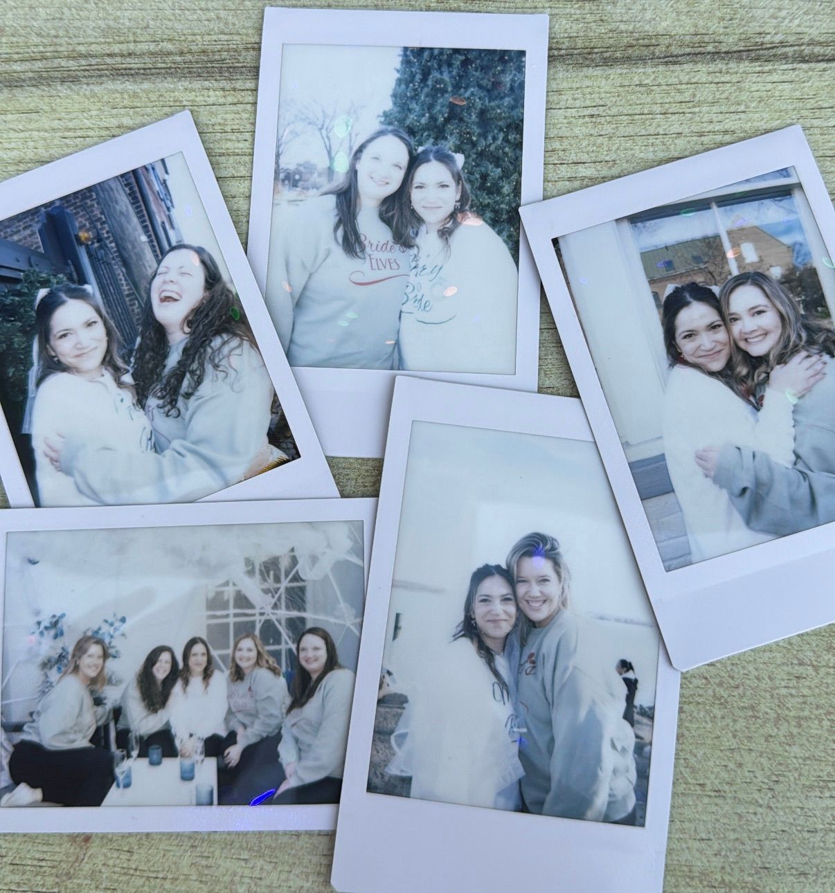 Five polaroid photos of bride surrounded by bridesmaids wearing matching sweatshirts — candid wedding celebration portrait