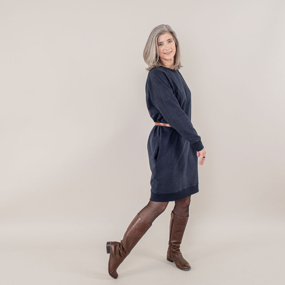 Woman in navy sweater and brown pants poses in different positions against white background.