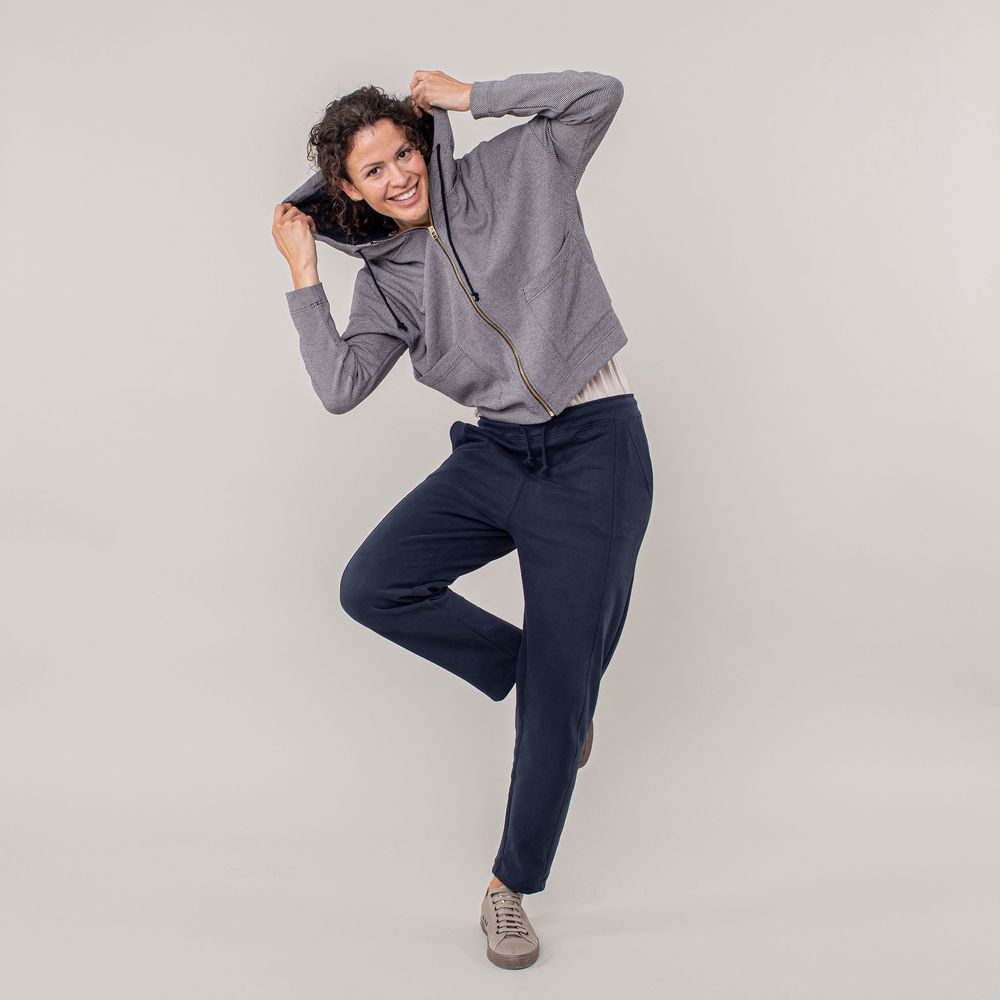 Person in striped shirt and navy pants strikes playful poses against white background in dynamic photo sequence.