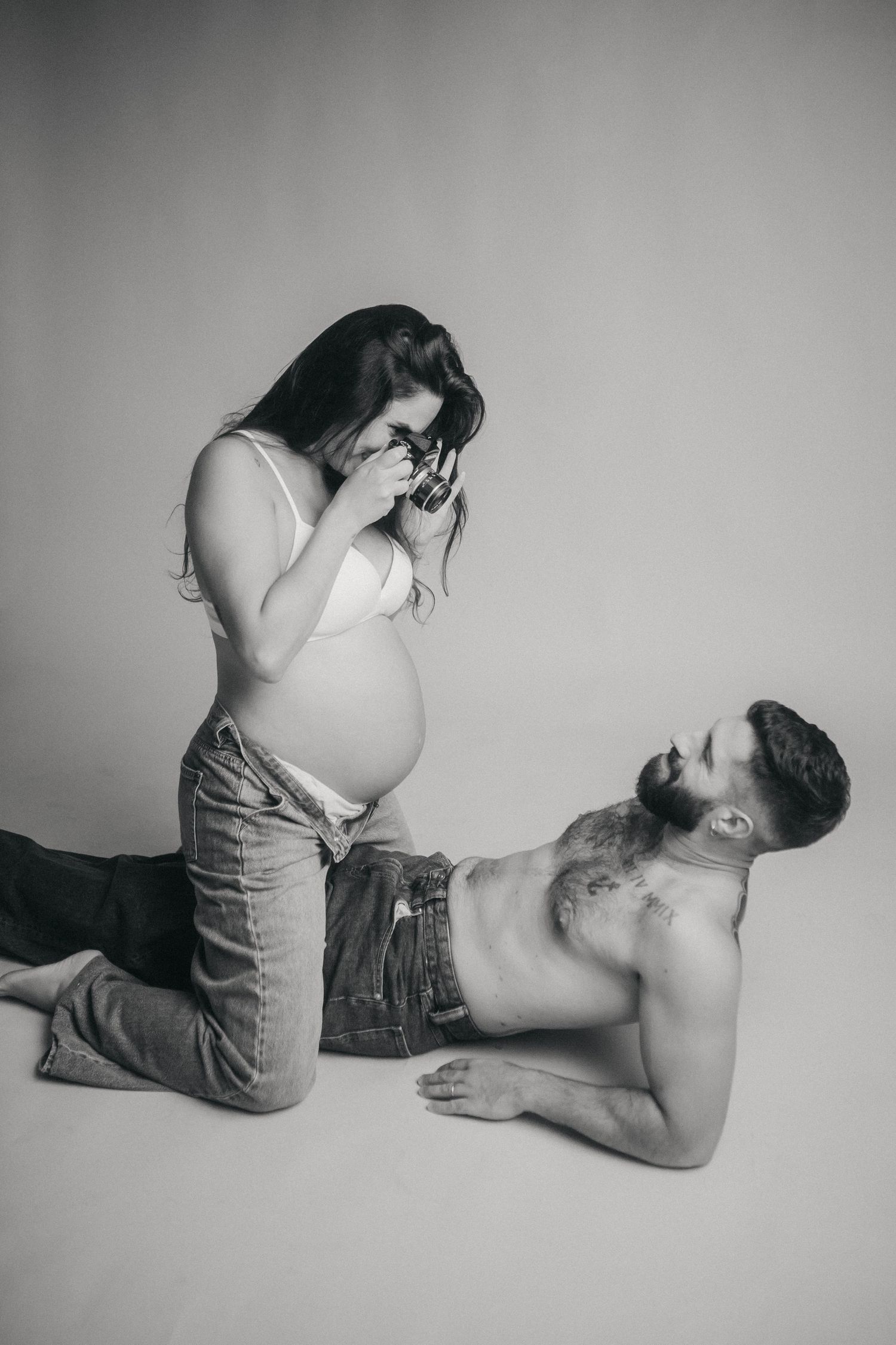 Pareja embarazada en estudio en blanco y negro con cámara analógica en Tarragona