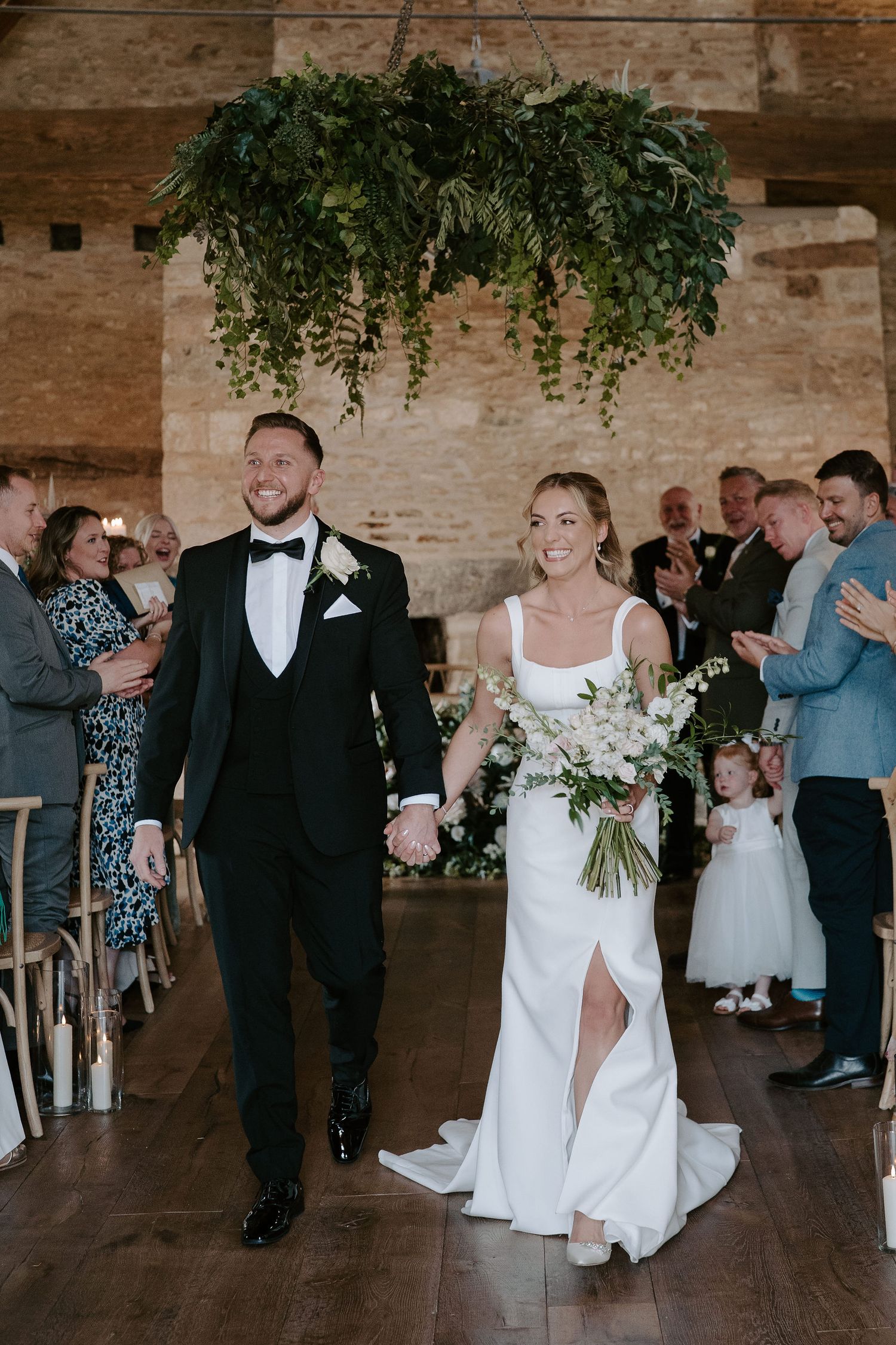 bride and groom walking down aisle as husband and wife exiting wedding ceremony at ivy lodge in cirencester
