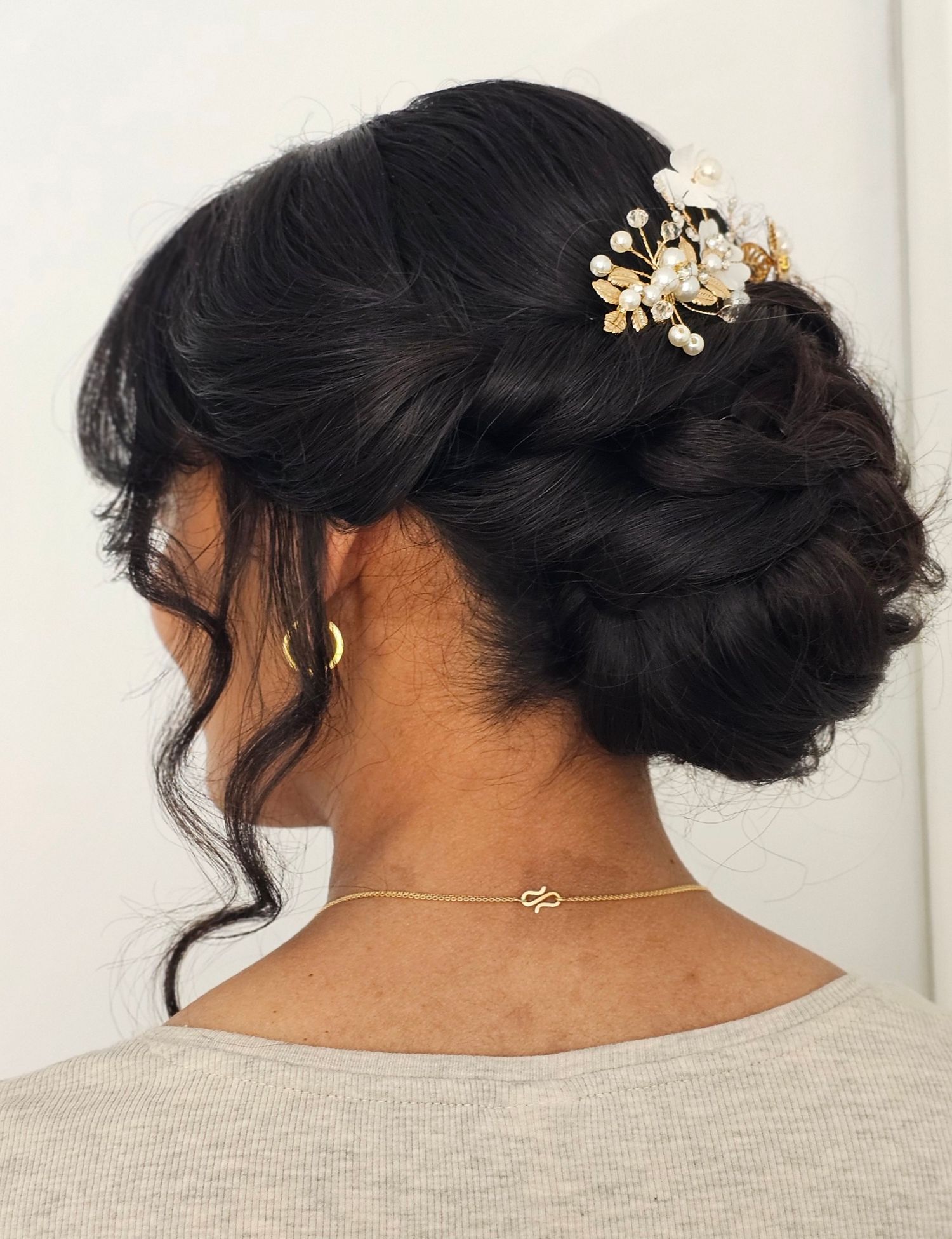 Large looped chignon bun with curled tendrils