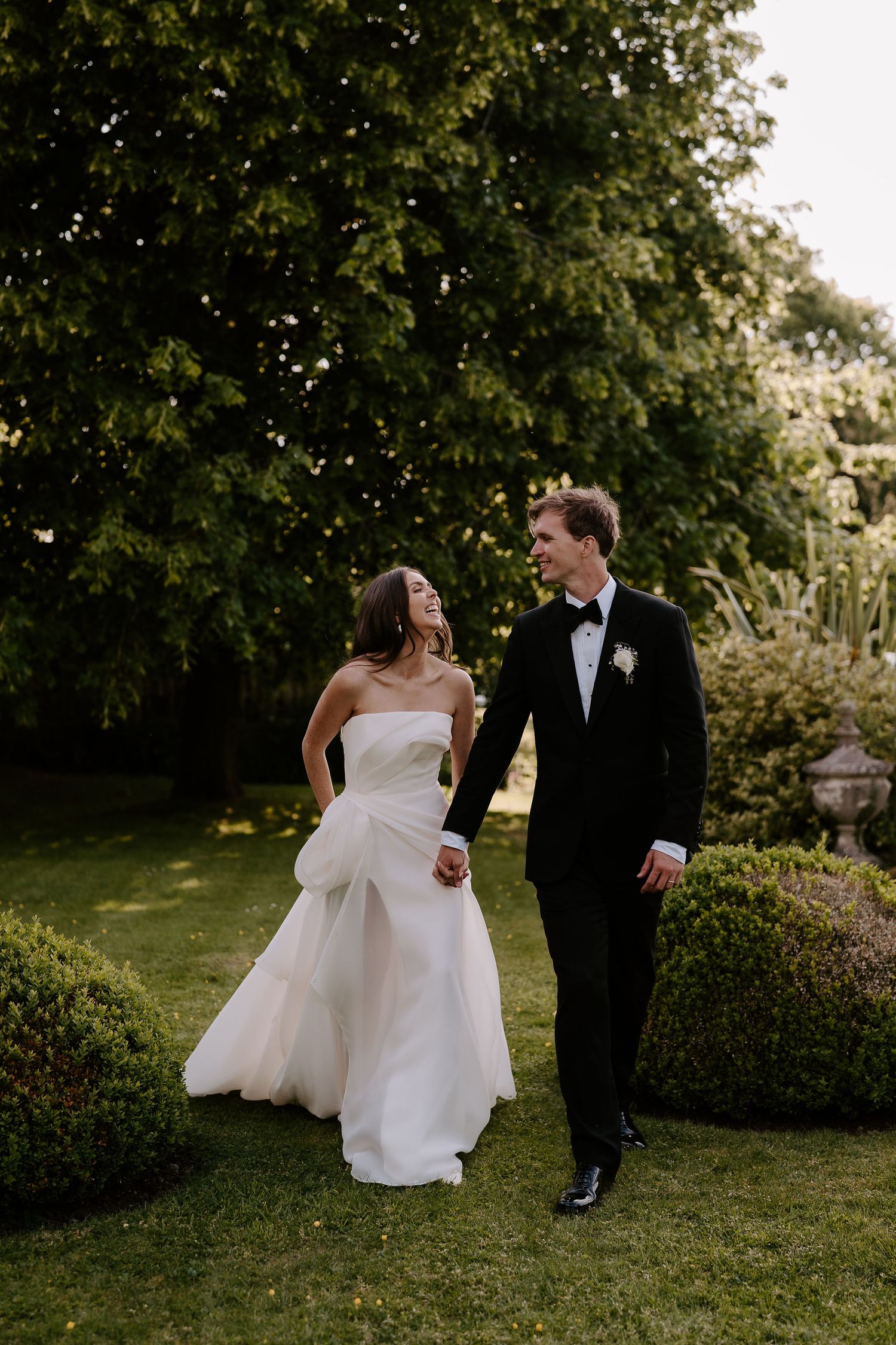 bride and groom walking, smiling at each other at dewsall court in herefordshire