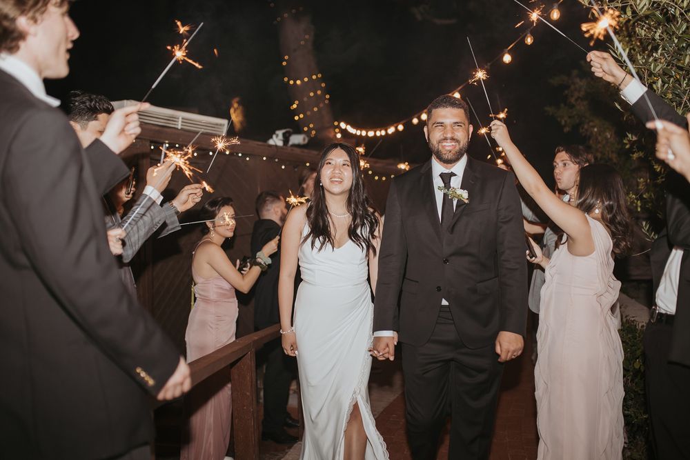 Wedding guests wave sparklers in celebration during a nighttime reception celebration at Inn of the Seventh Ray in Topanga, California.