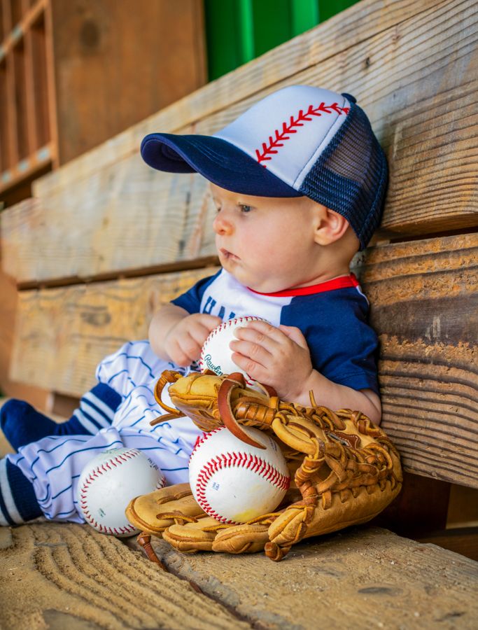 6 month old baby boy session half way there in williamsburg va
baseball dug out with a baseball glove and ball
wearing baseball outfit