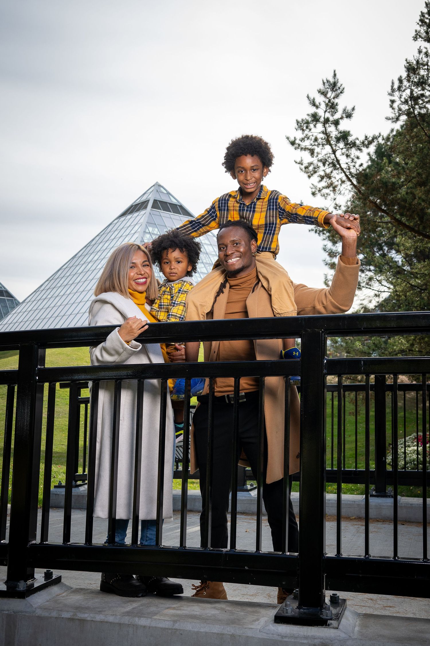Happy family enjoying time together on an outdoor deck with a geometric building structure in the background.