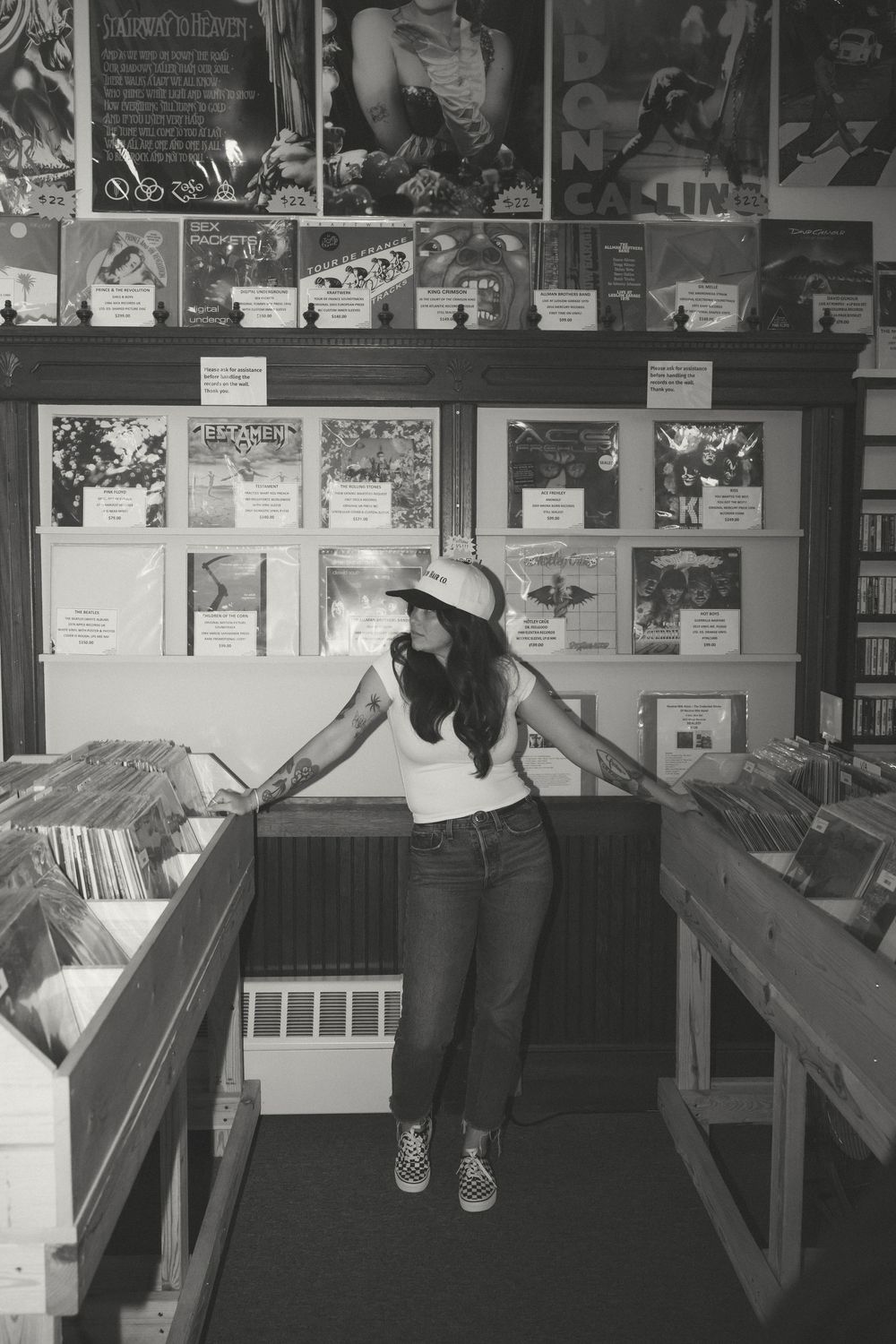 Black and white photograph showing vintage record store interior with rows of vinyl albums and display cases.