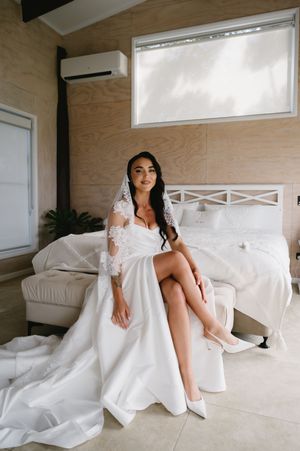 Elegant bridal portraits showing flowing white wedding dress details against light wooden walls.