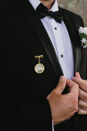Close-up details of a groom's formal tuxedo with pocket square and boutonniere.